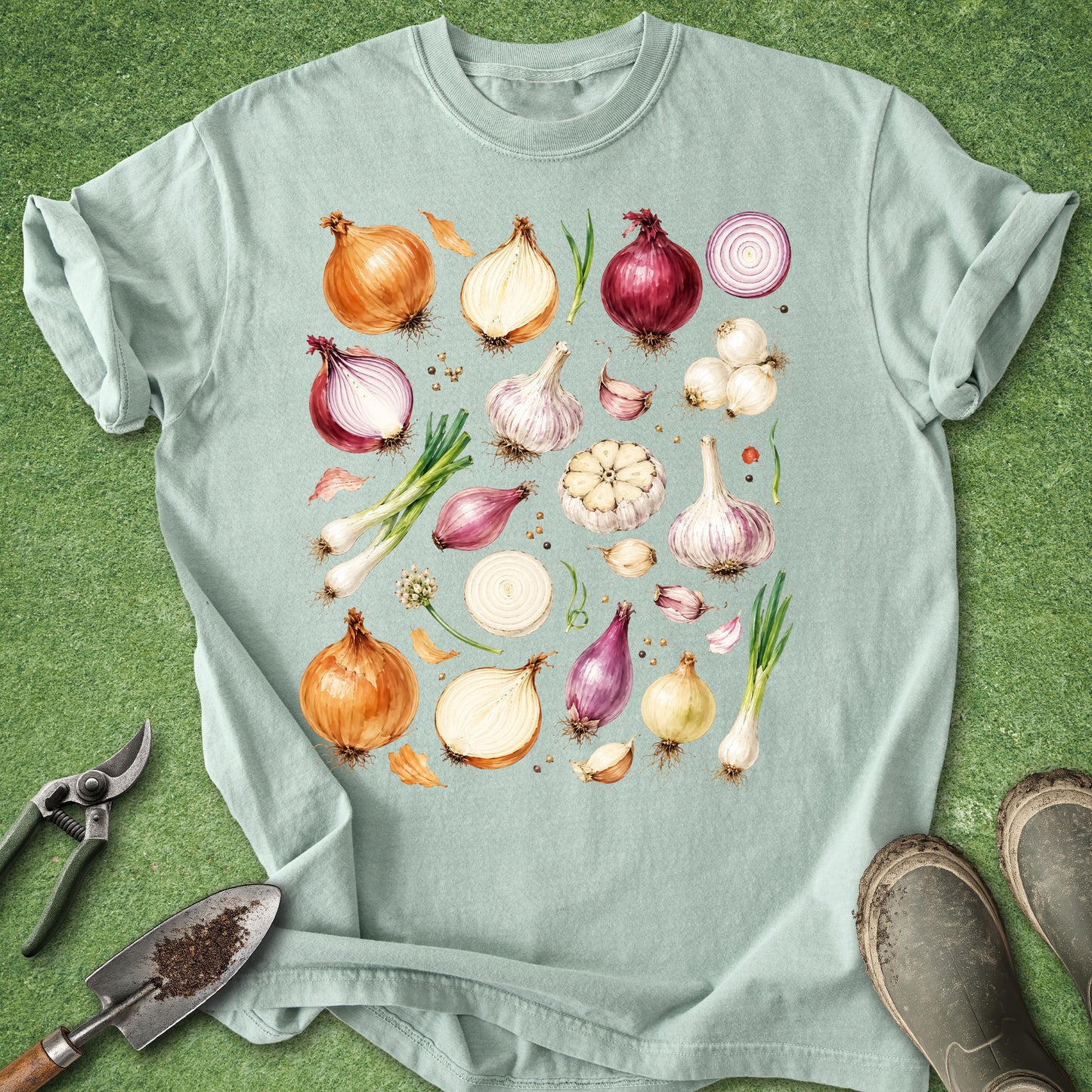Bay green t-shirt featuring a watercolor botanical collection of onions, garlic bulbs, shallots, scallions, sliced onions, garlic cloves, and garden harvest vegetables arranged in a detailed illustration.