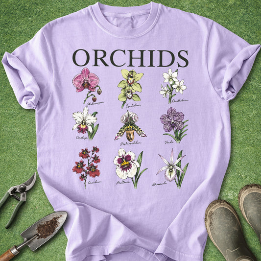Orchid-colored t-shirt featuring nine illustrated orchid flower varieties with their names in a vintage botanical chart design under the title "ORCHIDS".