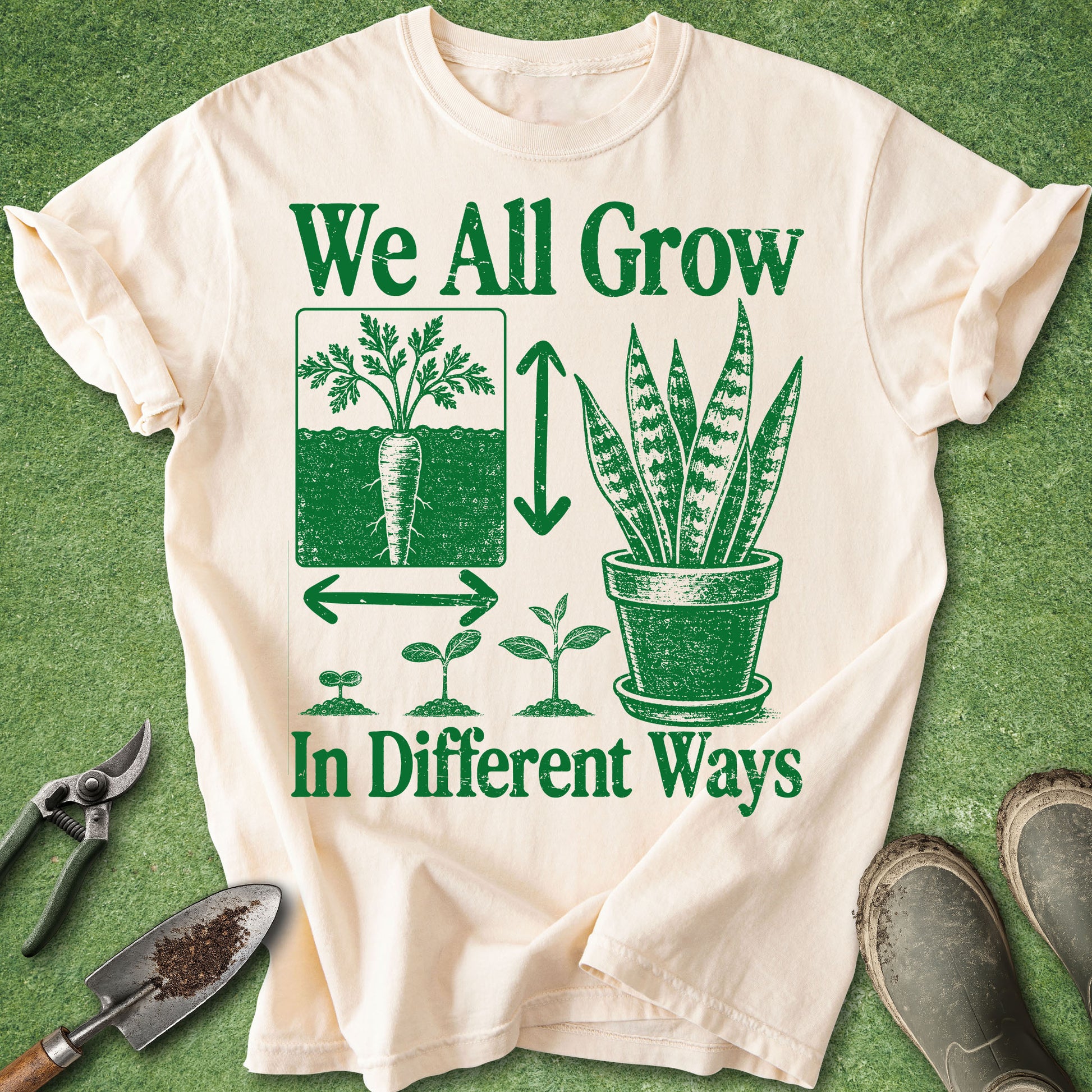Comfort Colors Ivory t-shirt featuring the phrase "We All Grow in Different Ways" with vintage green illustrations of a carrot, snake plant, seedling growth stages, and botanical graphics.