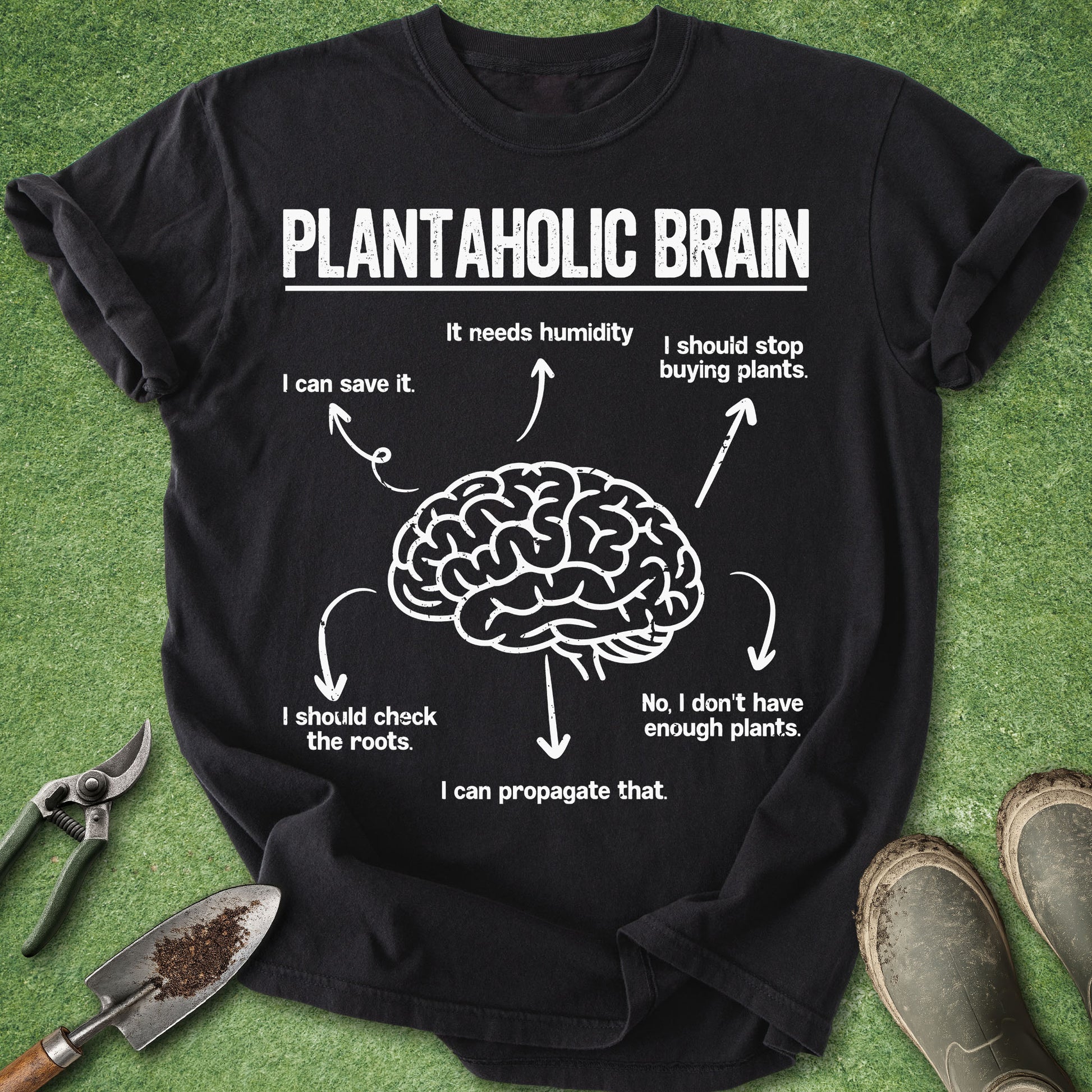 Black Comfort Colors t-shirt featuring a humorous Plantaholic Brain graphic with a brain illustration surrounded by plant lover thoughts including humidity, propagation, roots, and buying more plants.