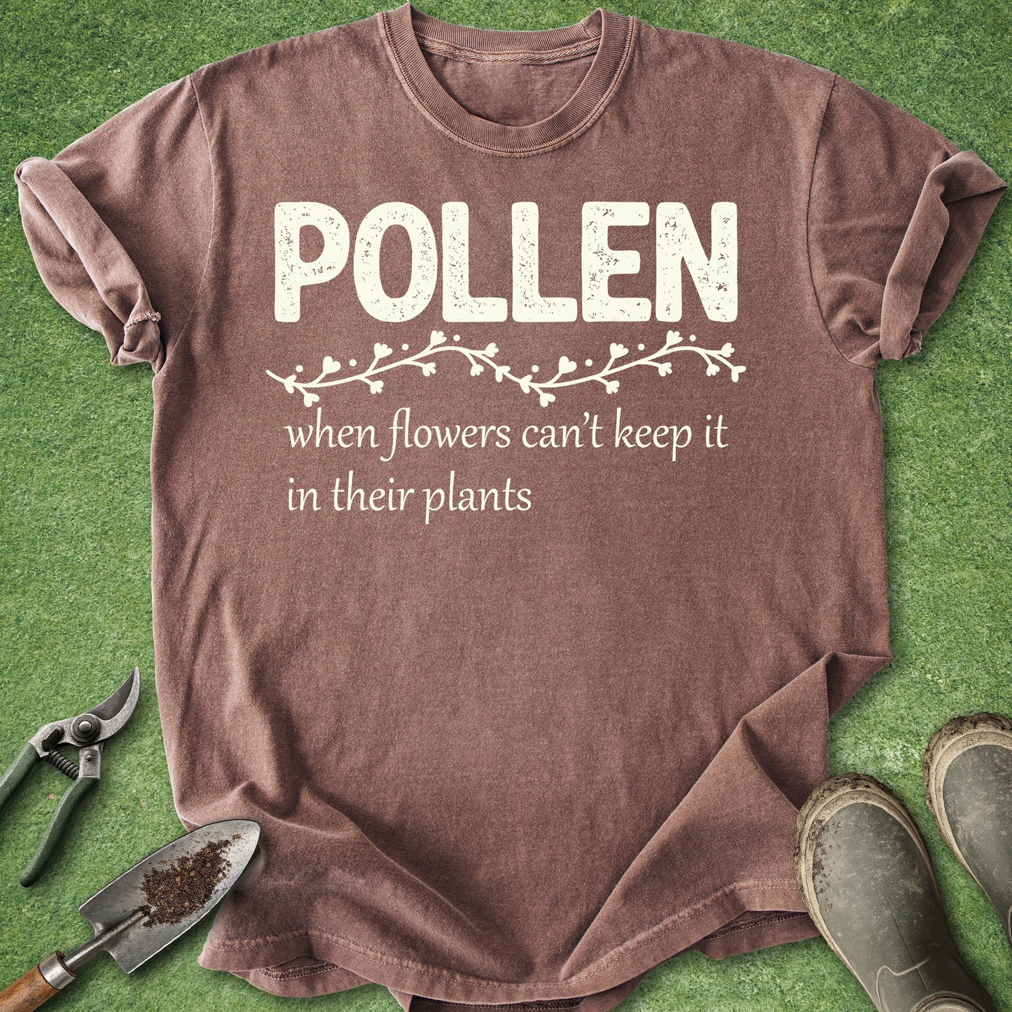 Brown t-shirt with 'Pollen' text on a green background with gardening tools.