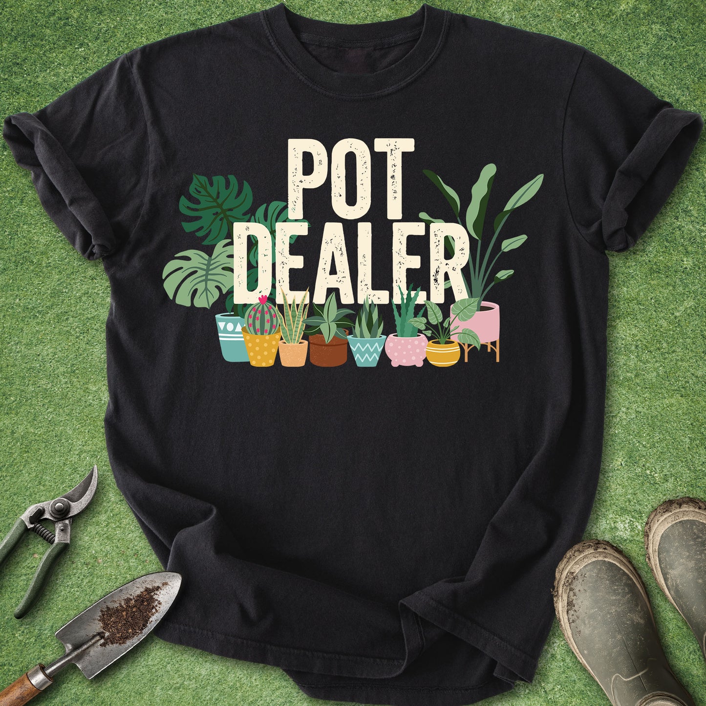 Black Comfort Colors t-shirt featuring the phrase "Pot Dealer" above colorful illustrated potted houseplants including monstera, snake plants, cactus, and tropical foliage in decorative planters.