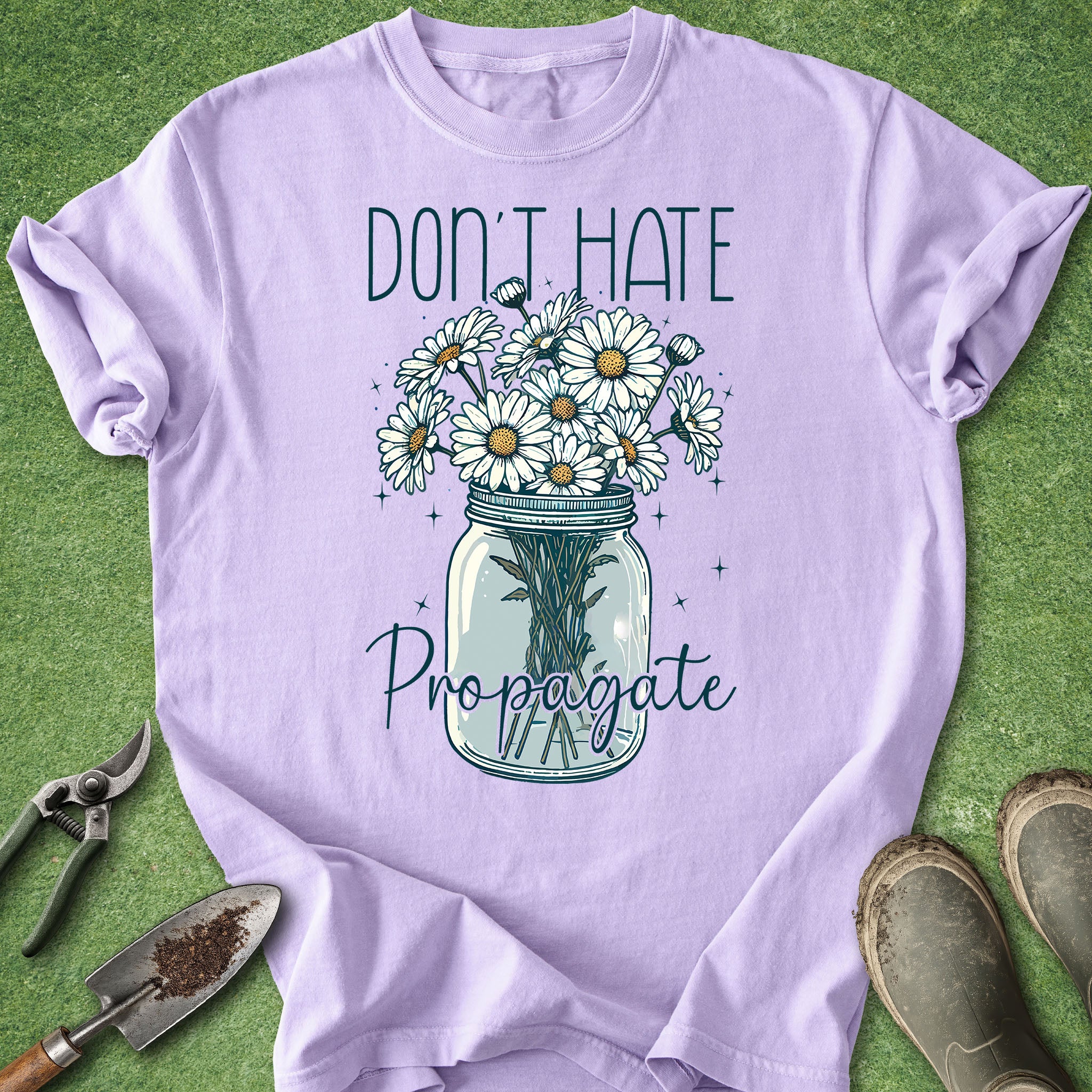 Purple t-shirt with a graphic of flowers in a jar and text 'Don't Hate Propagate' on a green background.
