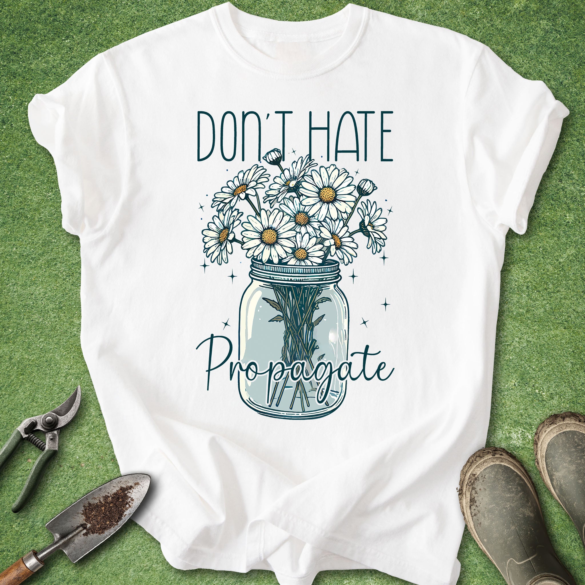 White t-shirt with floral design and text 'Don't Hate Propagate' on a green background