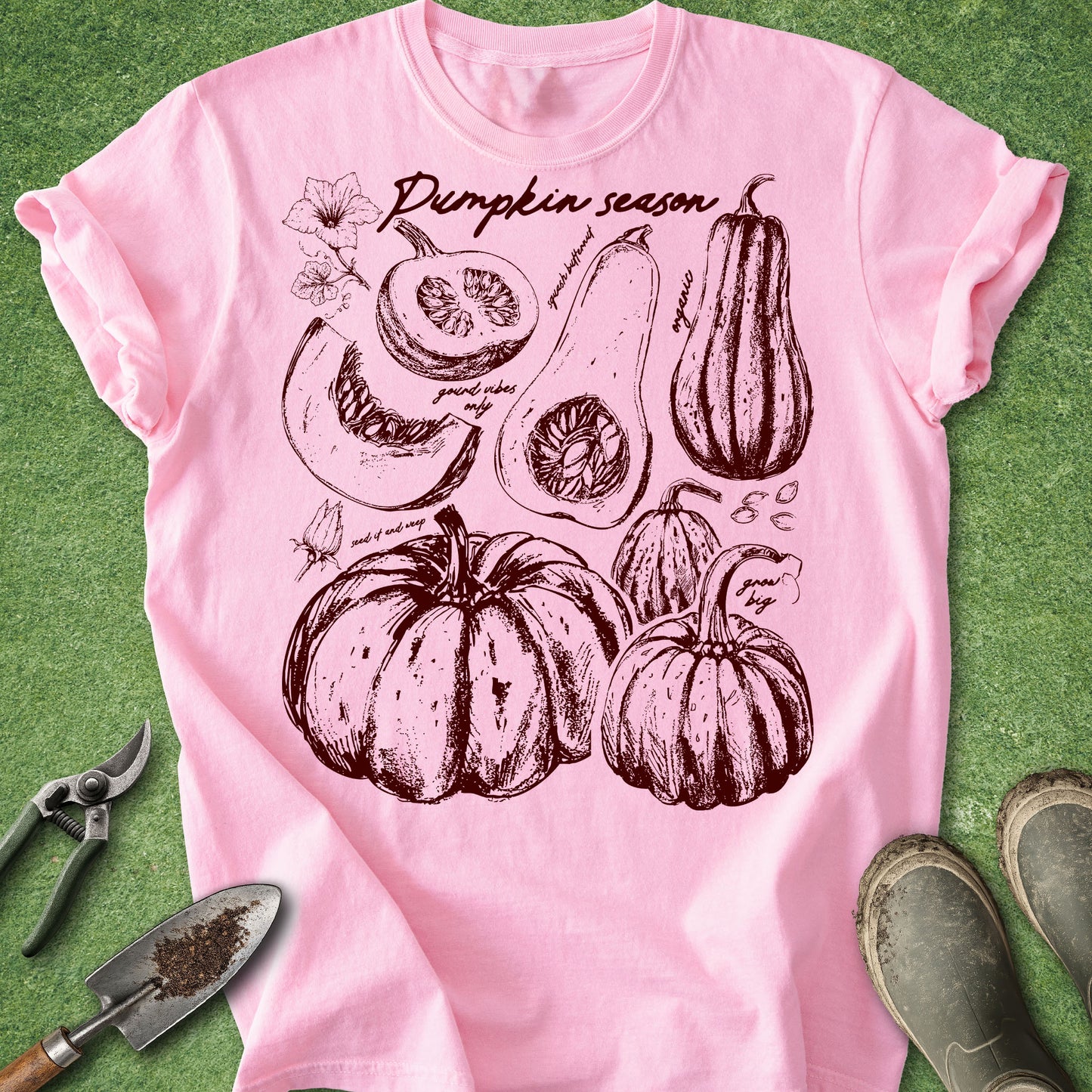 Pink t-shirt with pumpkin season design on a green background