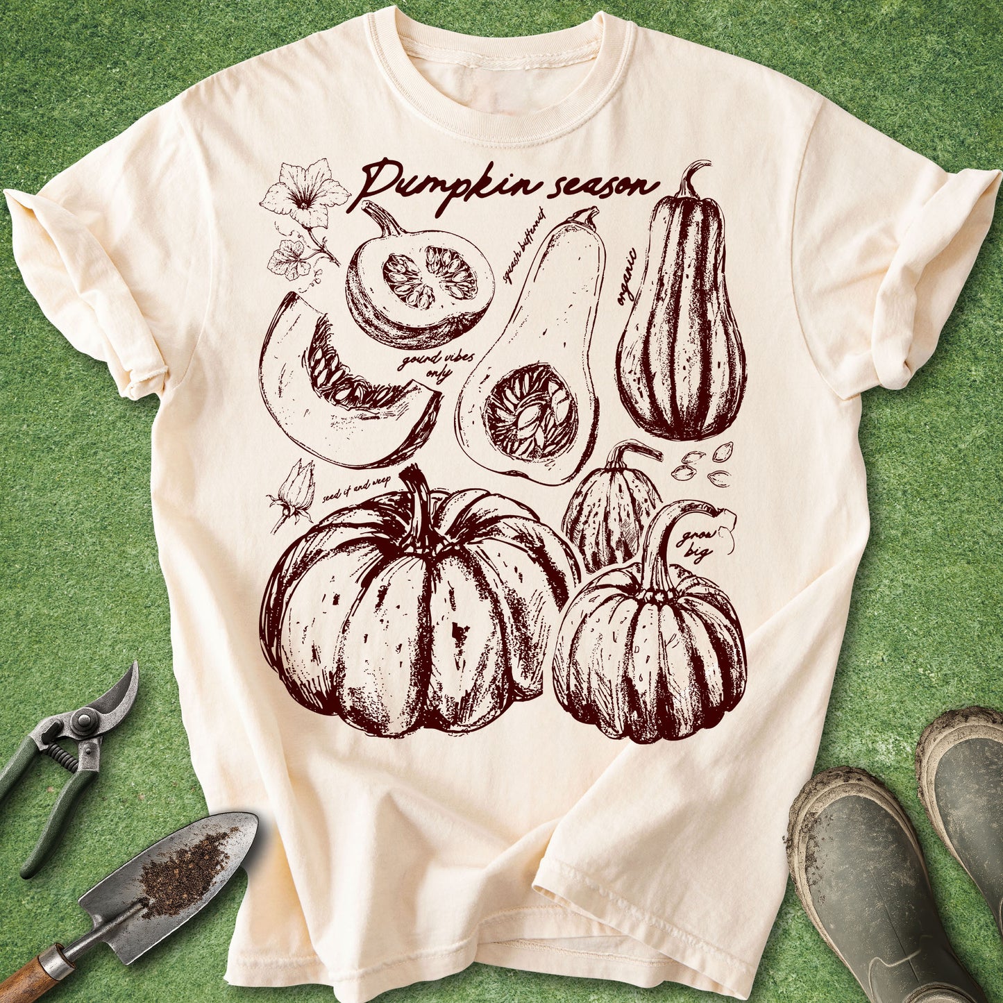 Ivory Comfort Colors t-shirt featuring vintage botanical illustrations of pumpkins, squash, pumpkin seeds, and blossoms with a pumpkin season theme arranged in a harvest-inspired garden journal design.