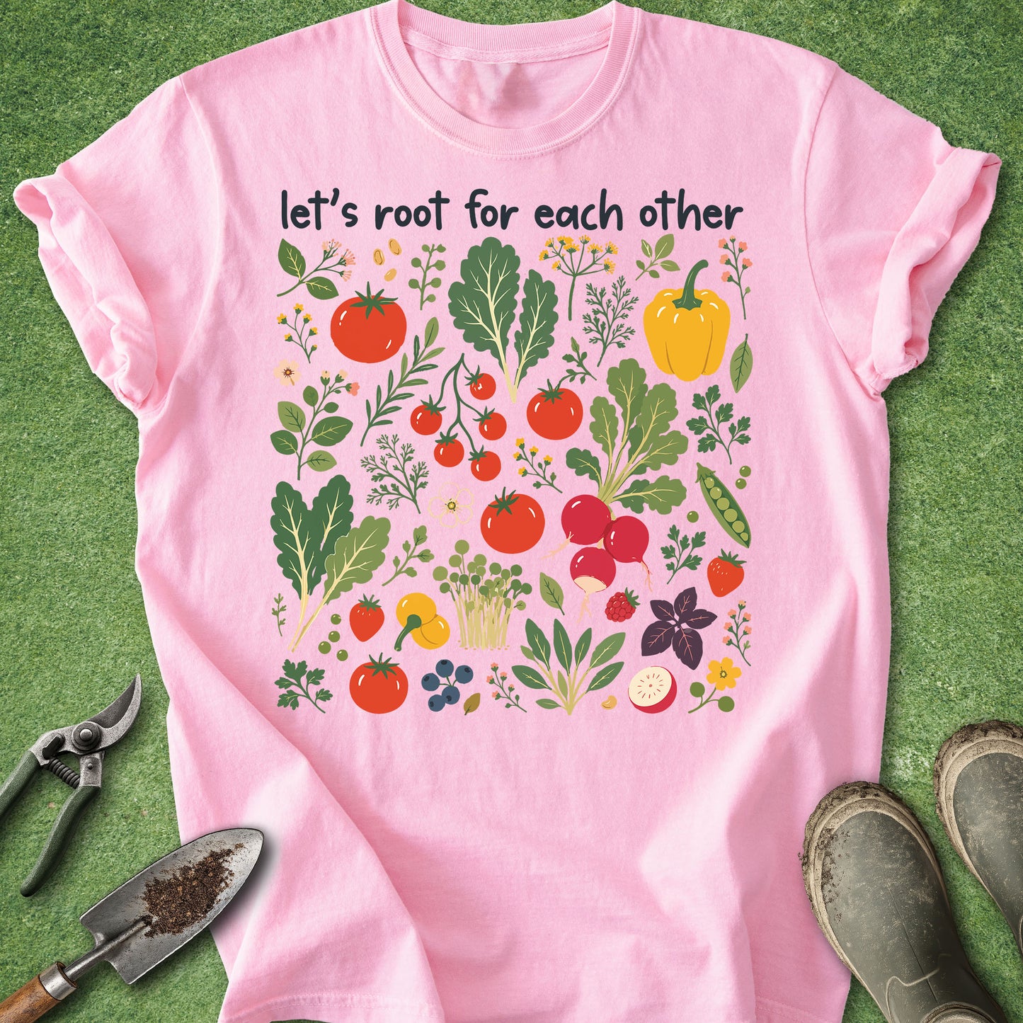 Pink t-shirt with vegetable graphics and text 'let's root for each other' on a green background