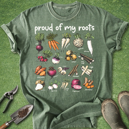 Green t-shirt with vegetable illustrations and 'proud of my roots' text on a grass background.