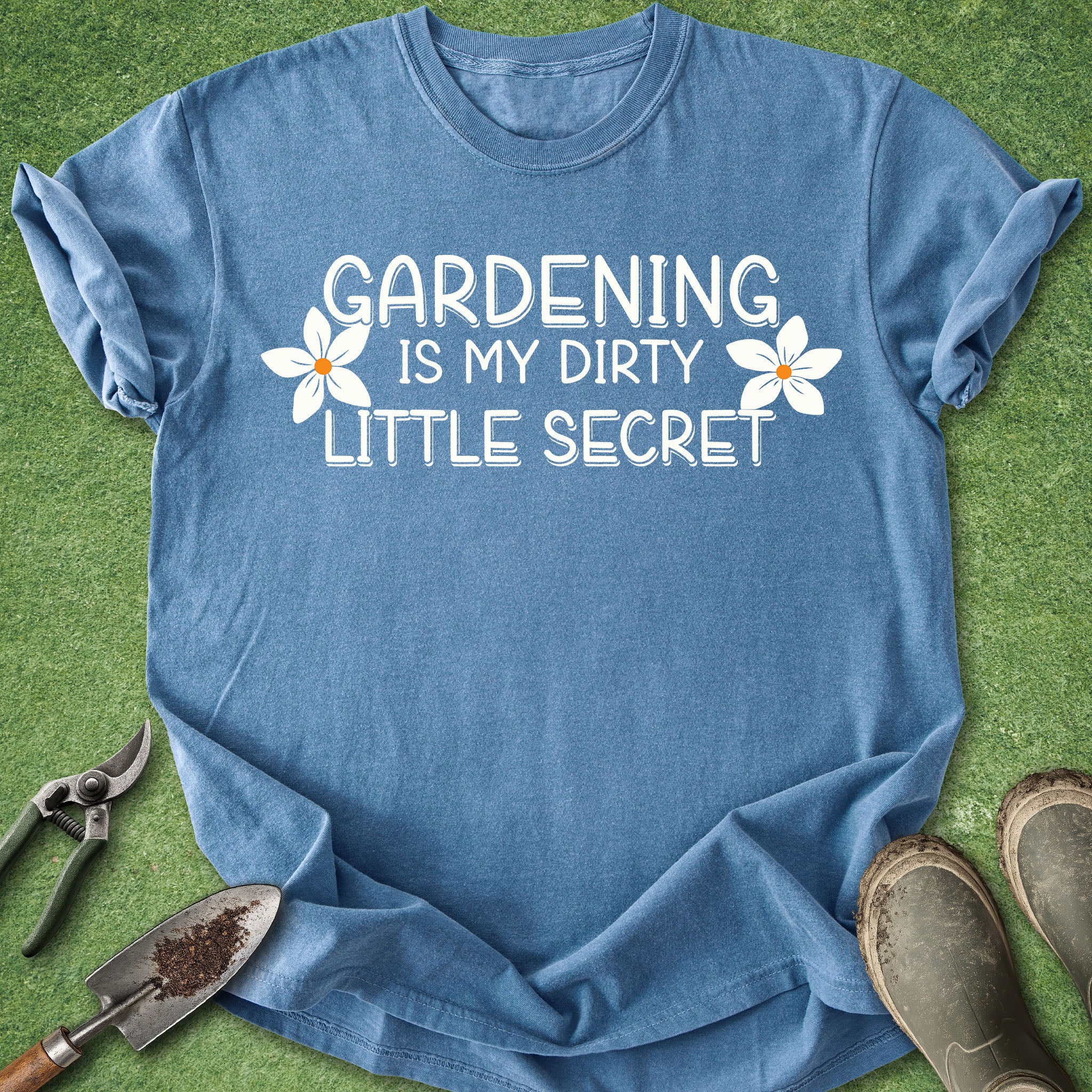 Blue t-shirt with 'Gardening is my dirty little secret' text on a grass background