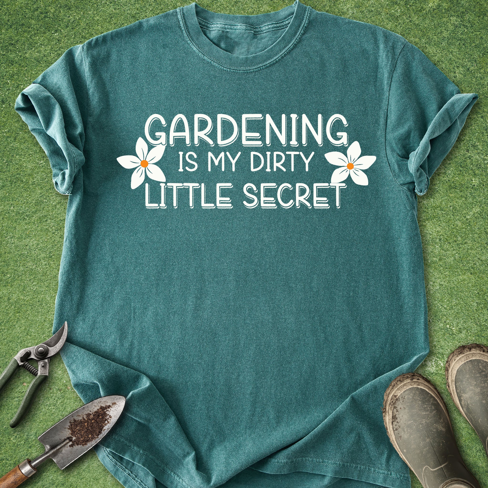 Teal t-shirt with 'Gardening is my dirty little secret' text on a grass background