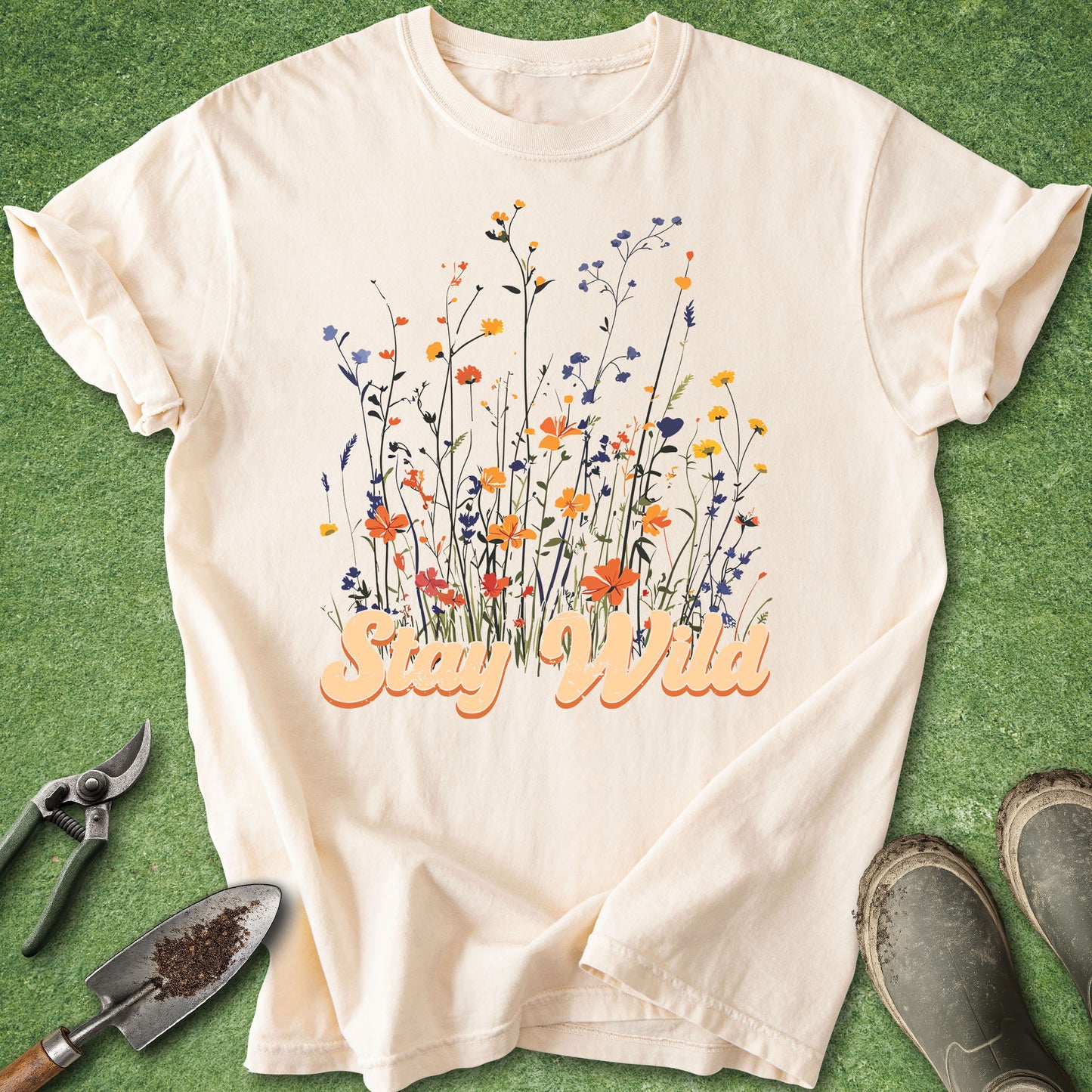 Beige t-shirt with floral design and 'Stay Wild' text on a green background