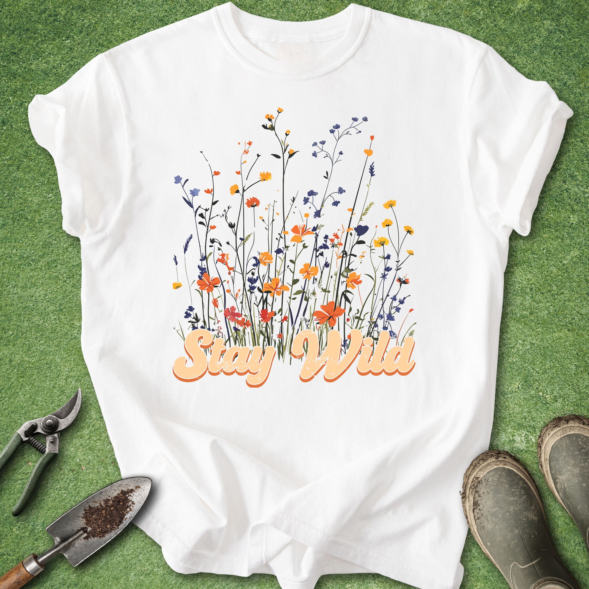 White t-shirt with floral design and 'Stay Wild' text on a green background