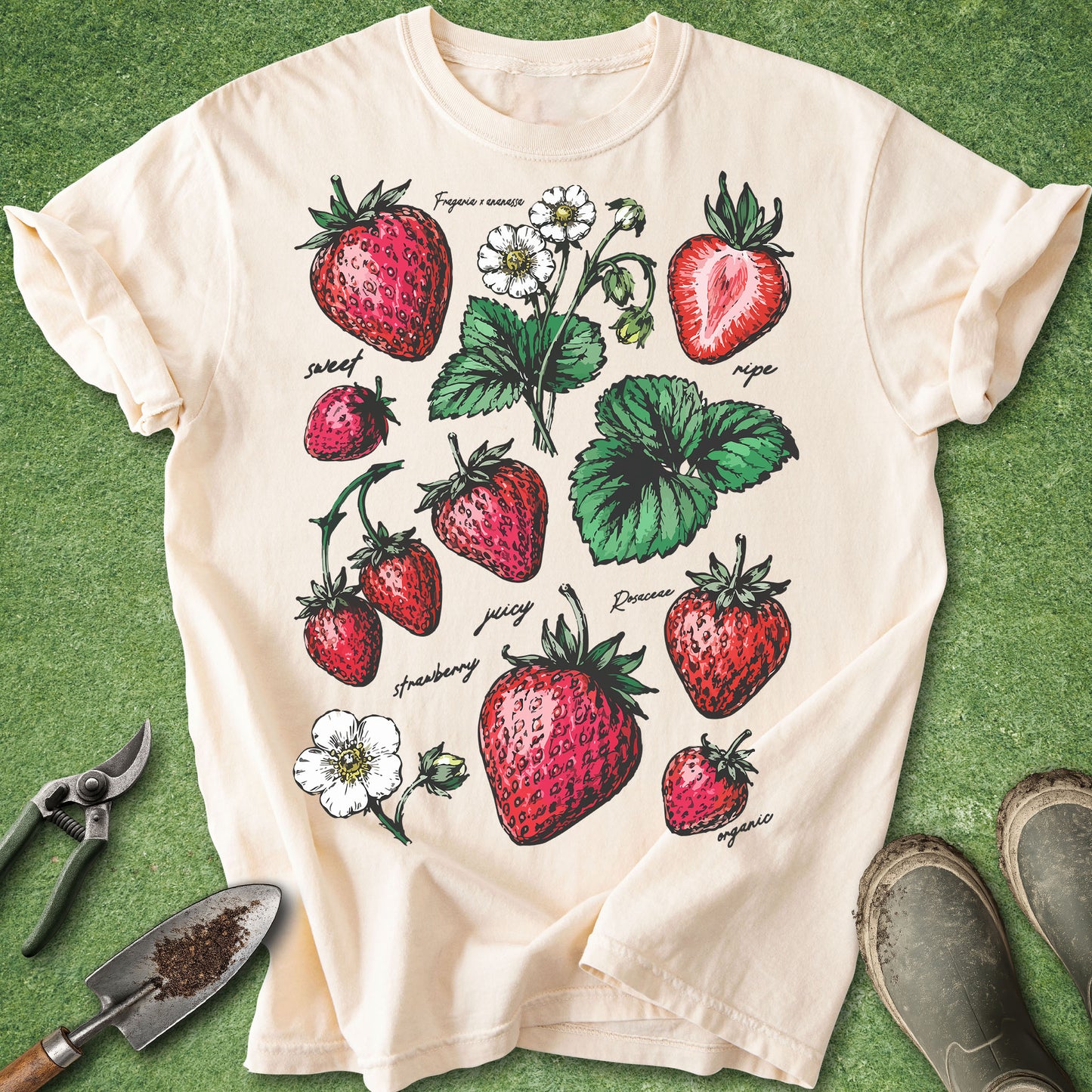 Beige t-shirt with strawberry design on a green grass background