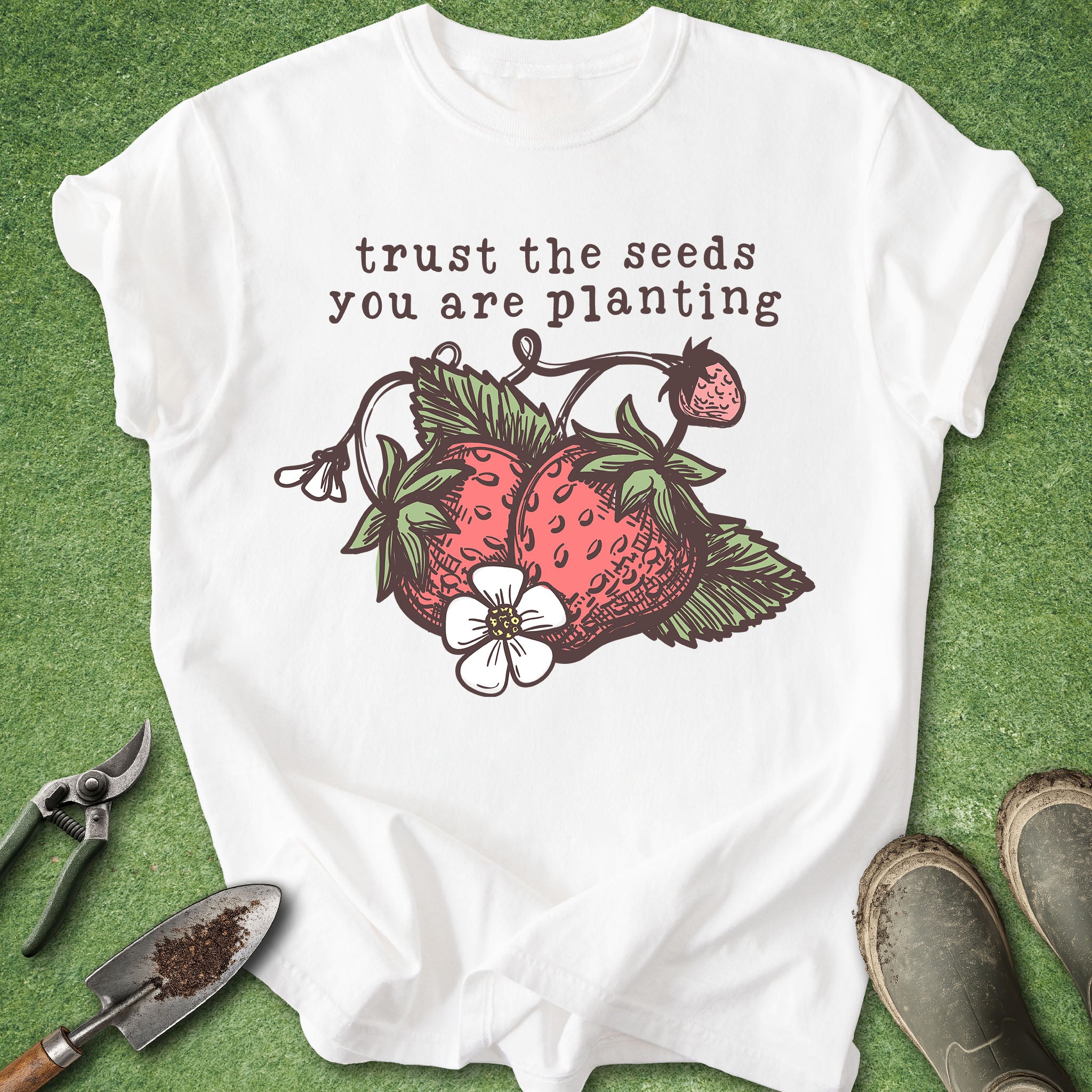 White t-shirt with strawberry design and text on a green background