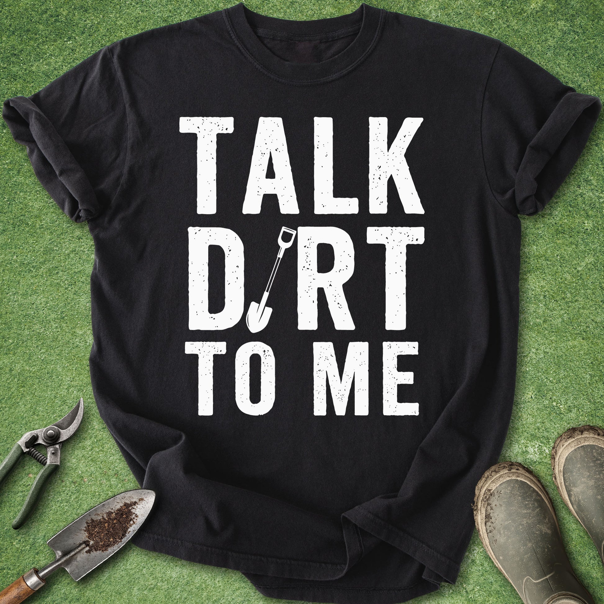 Black t-shirt with 'Talk Dirt to Me' text on a green background with gardening tools.