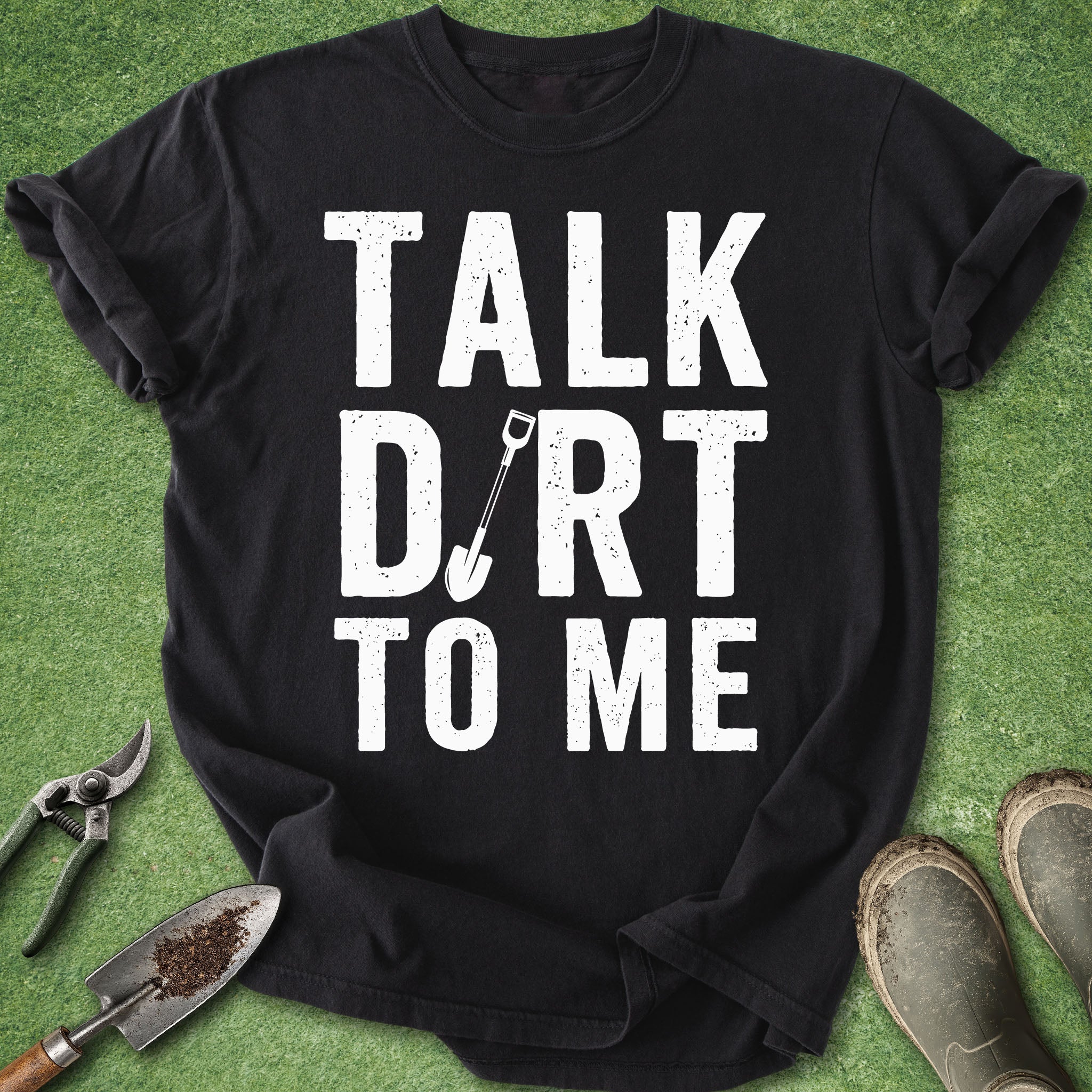 Black t-shirt with 'Talk Dirt to Me' text on a green background with gardening tools.