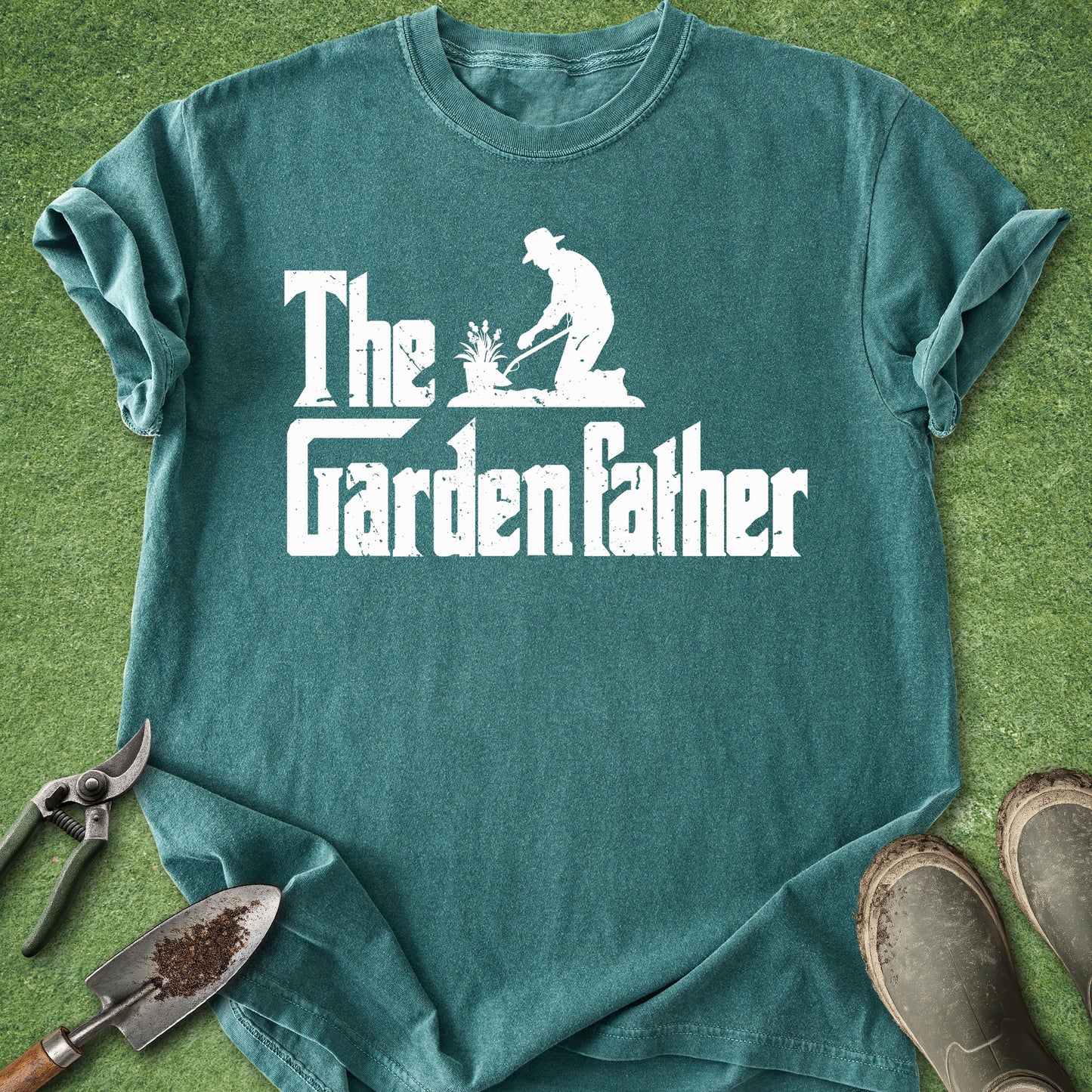Teal t-shirt with 'The Garden Father' graphic on a grass background