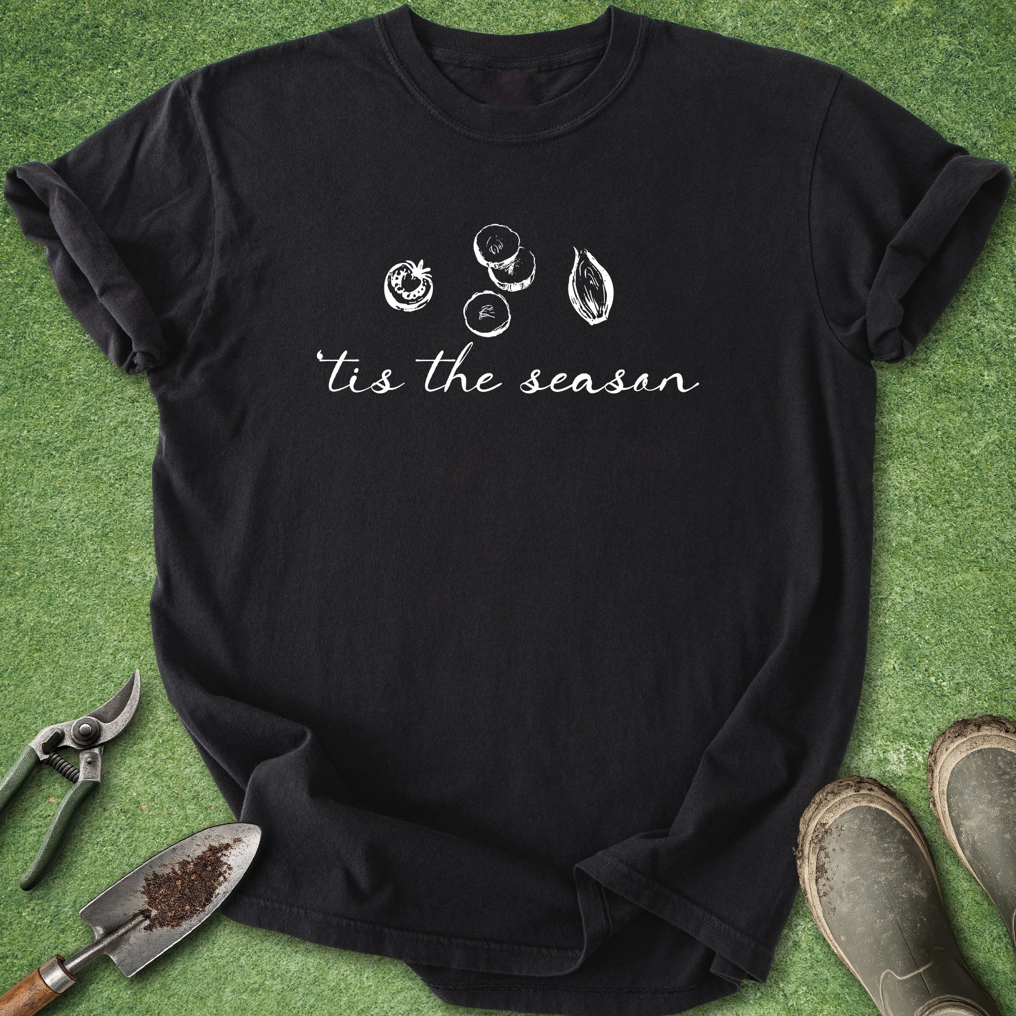 Black t-shirt with 'tis the season' text and illustrations on a green grass background.