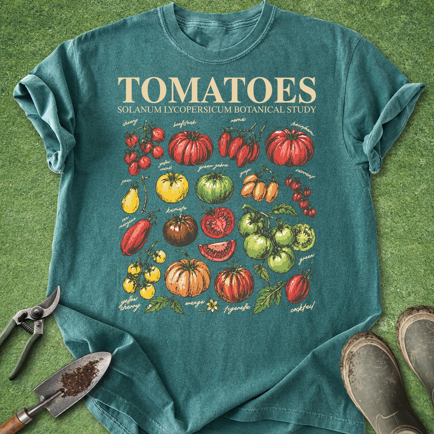 Teal t-shirt with tomato illustration on a grass background