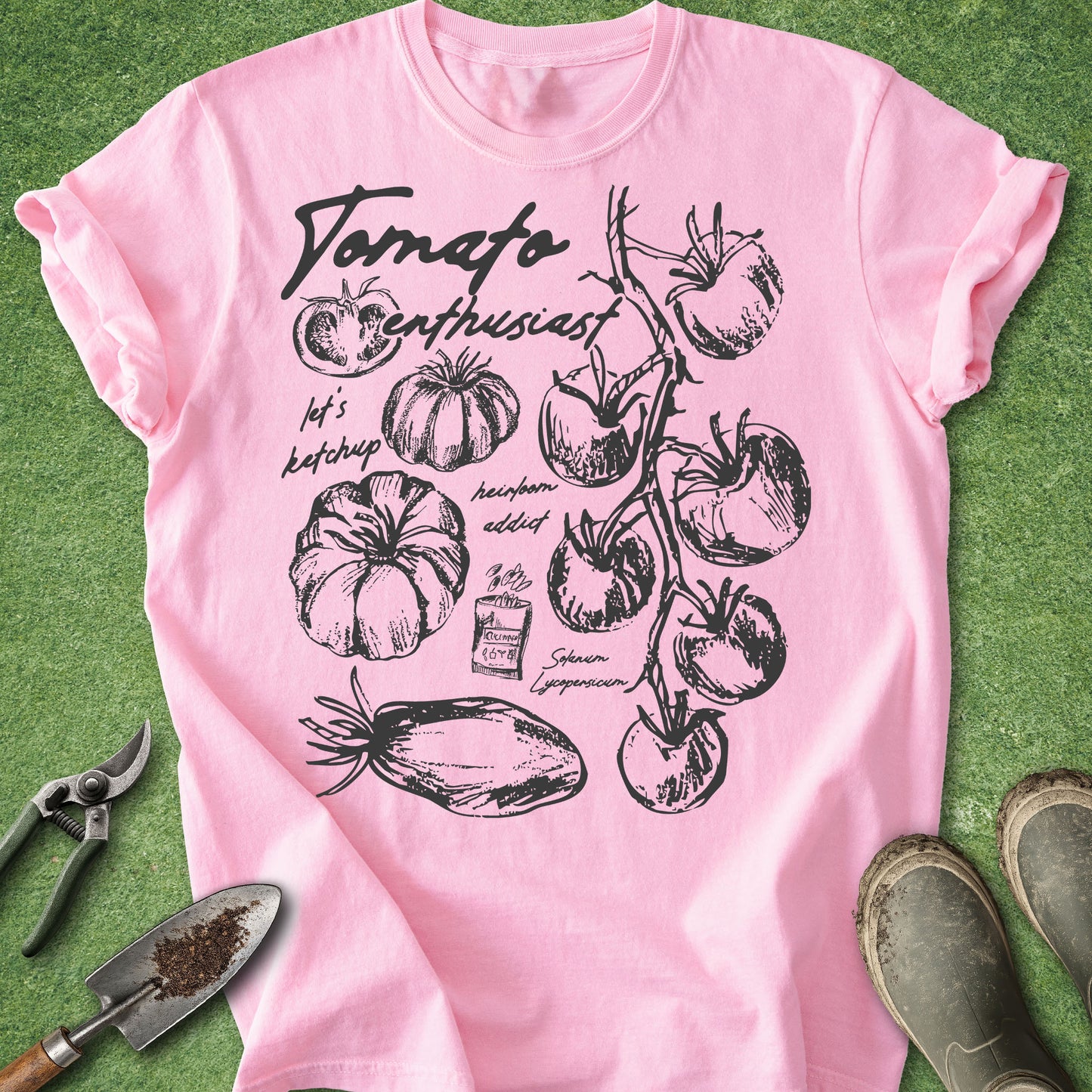 Pink t-shirt with tomato-themed design on a green background