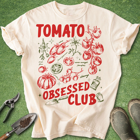Ivory Comfort Colors t-shirt featuring a colorful Tomato Obsessed Club design with vintage-style tomato illustrations, tomato blossoms, cherry tomatoes, heirloom varieties, gardening tools, and garden-themed artwork.