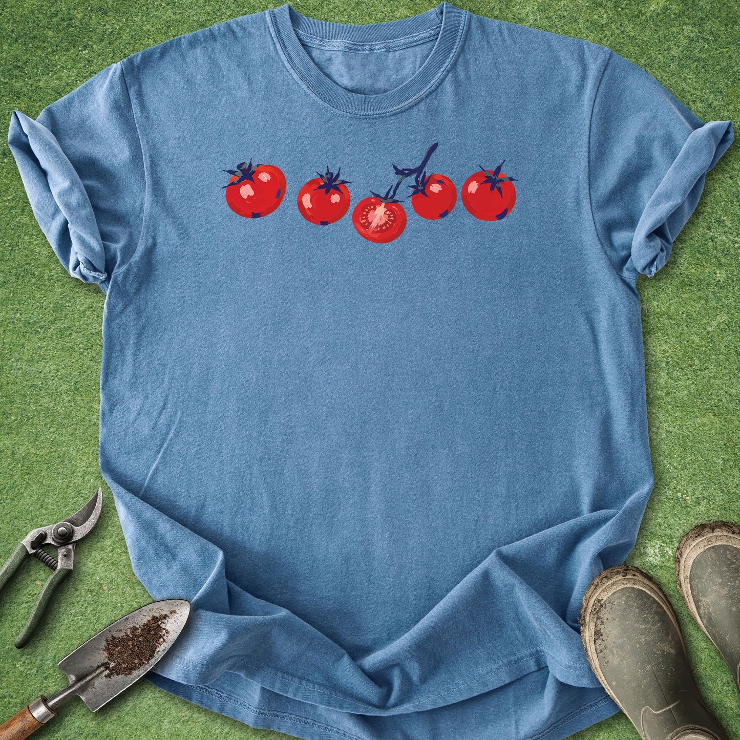 Blue t-shirt with tomato design on a green grass background