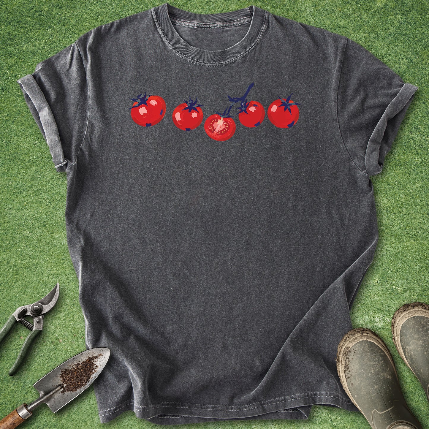 Gray t-shirt with red tomato design on a green grass background