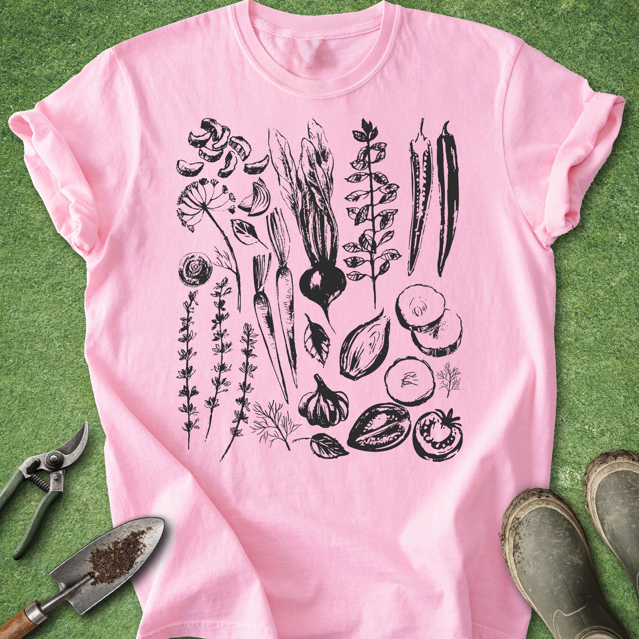 Pink t-shirt with black botanical illustrations on a green background