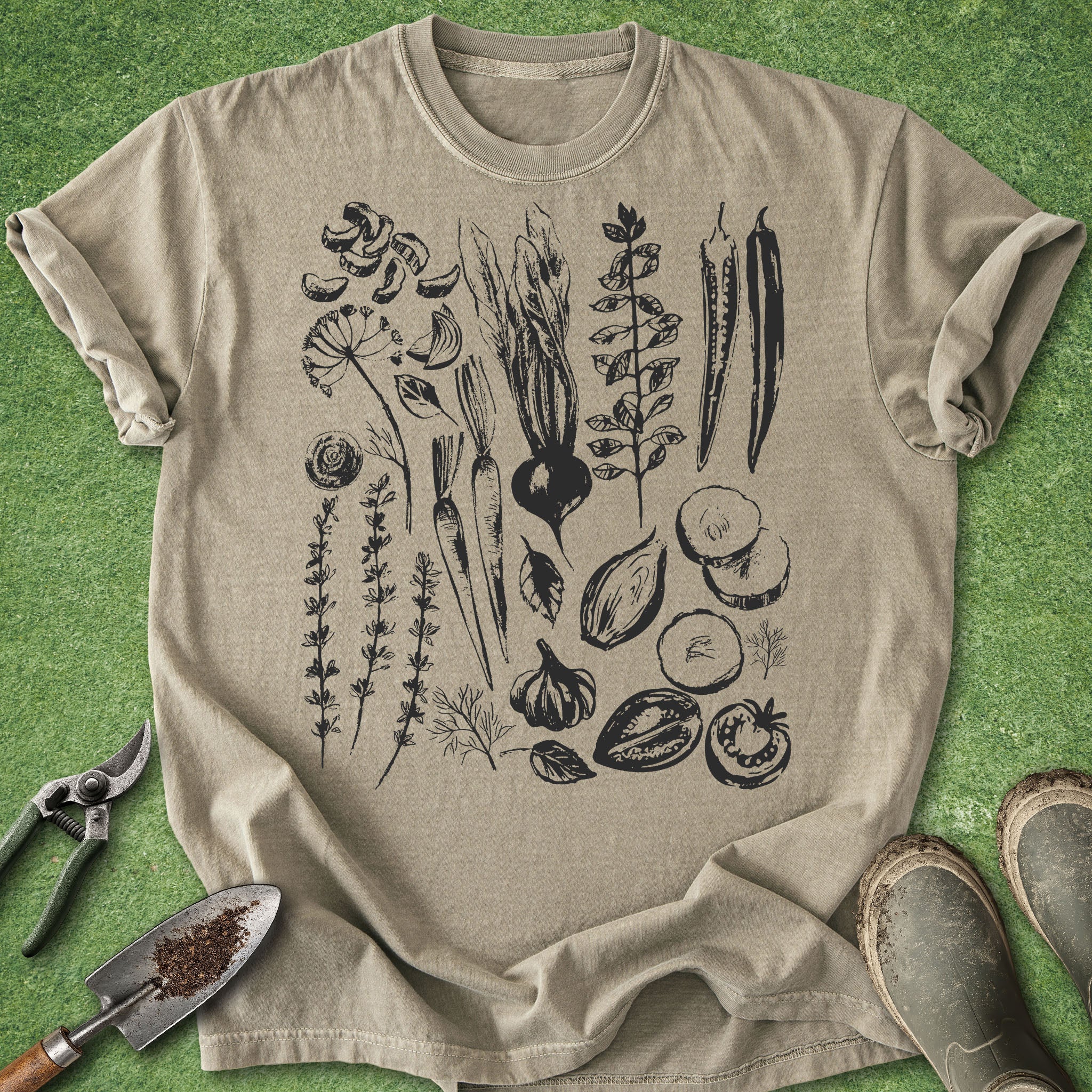 Beige t-shirt with black botanical illustrations on a green grass background