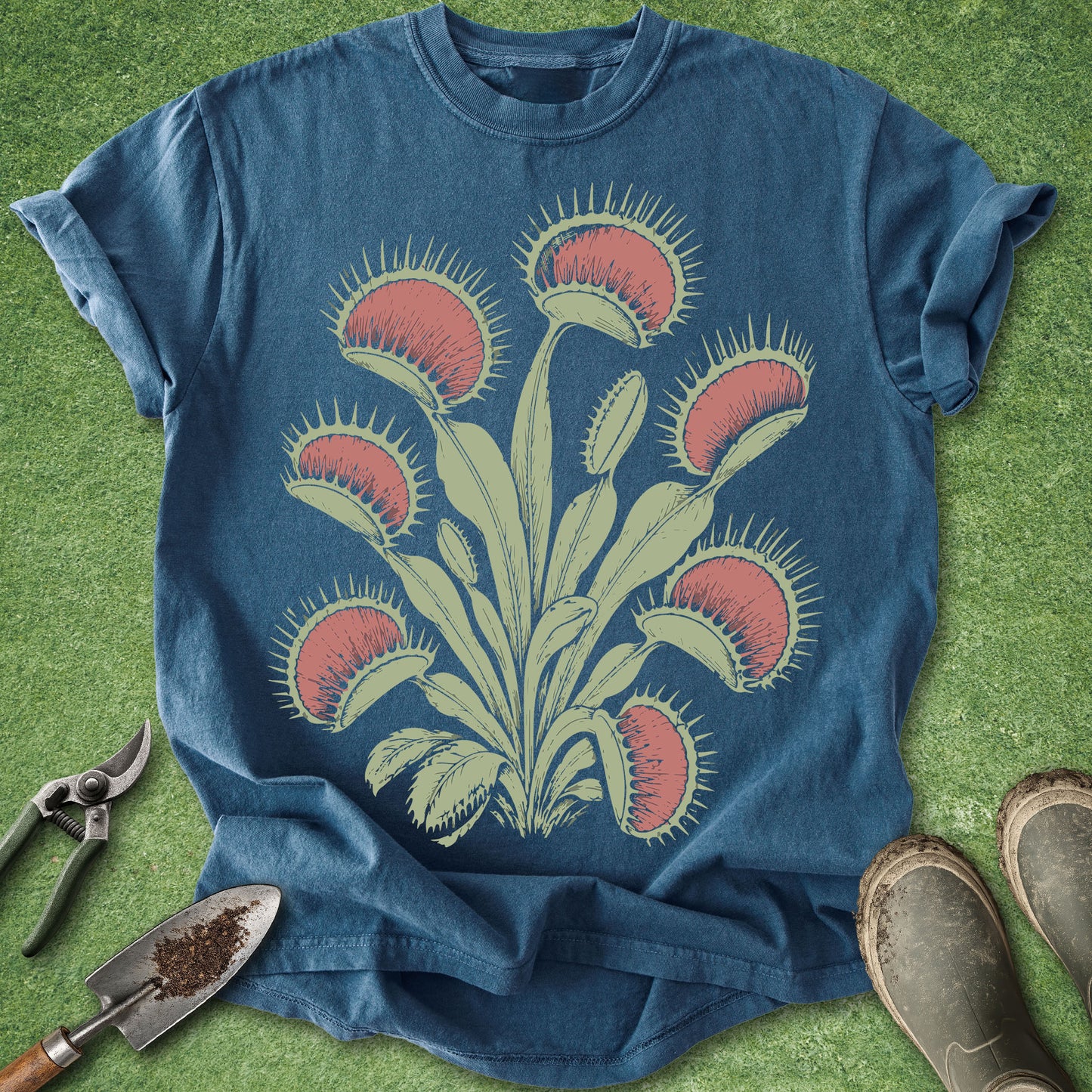 Blue t-shirt with Venus flytrap design on a green grass background
