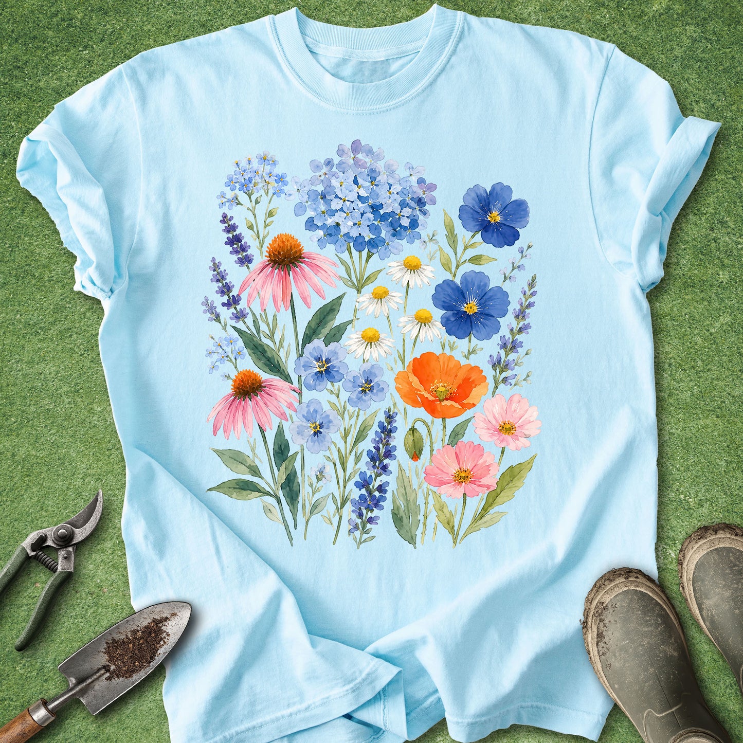 Chambray blue t-shirt featuring a colorful watercolor bouquet of wildflowers including hydrangeas, lavender, daisies, coneflowers, cosmos, poppies, and forget-me-nots in a botanical floral arrangement.