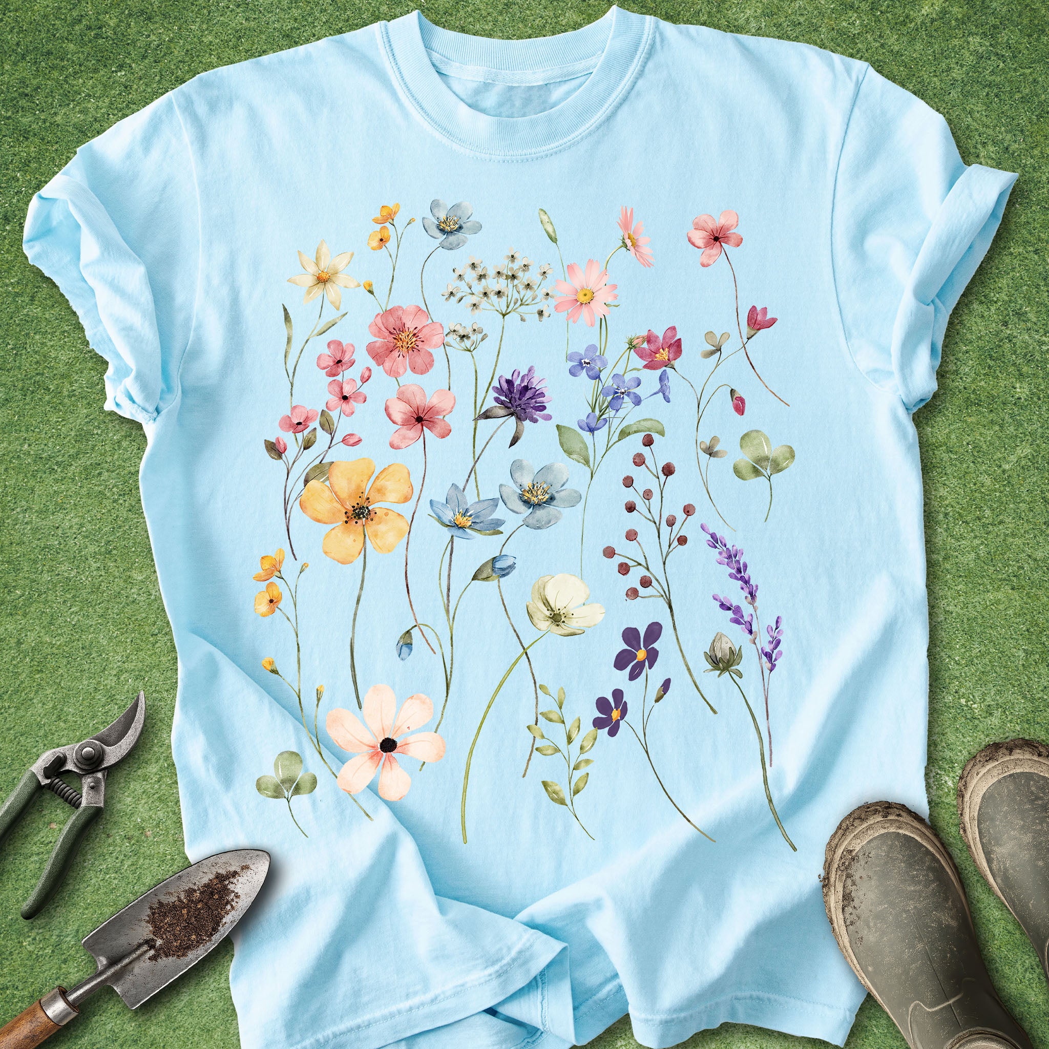 Light blue t-shirt with floral design on a green grass background