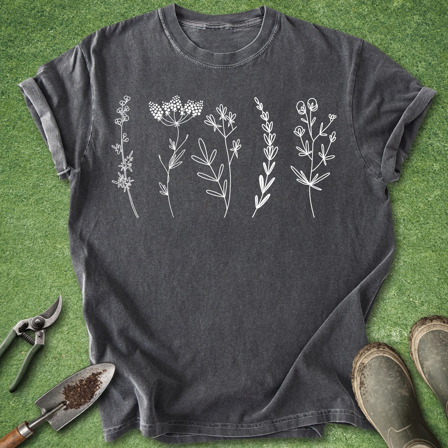Dark gray t-shirt with white floral designs on a green grass background