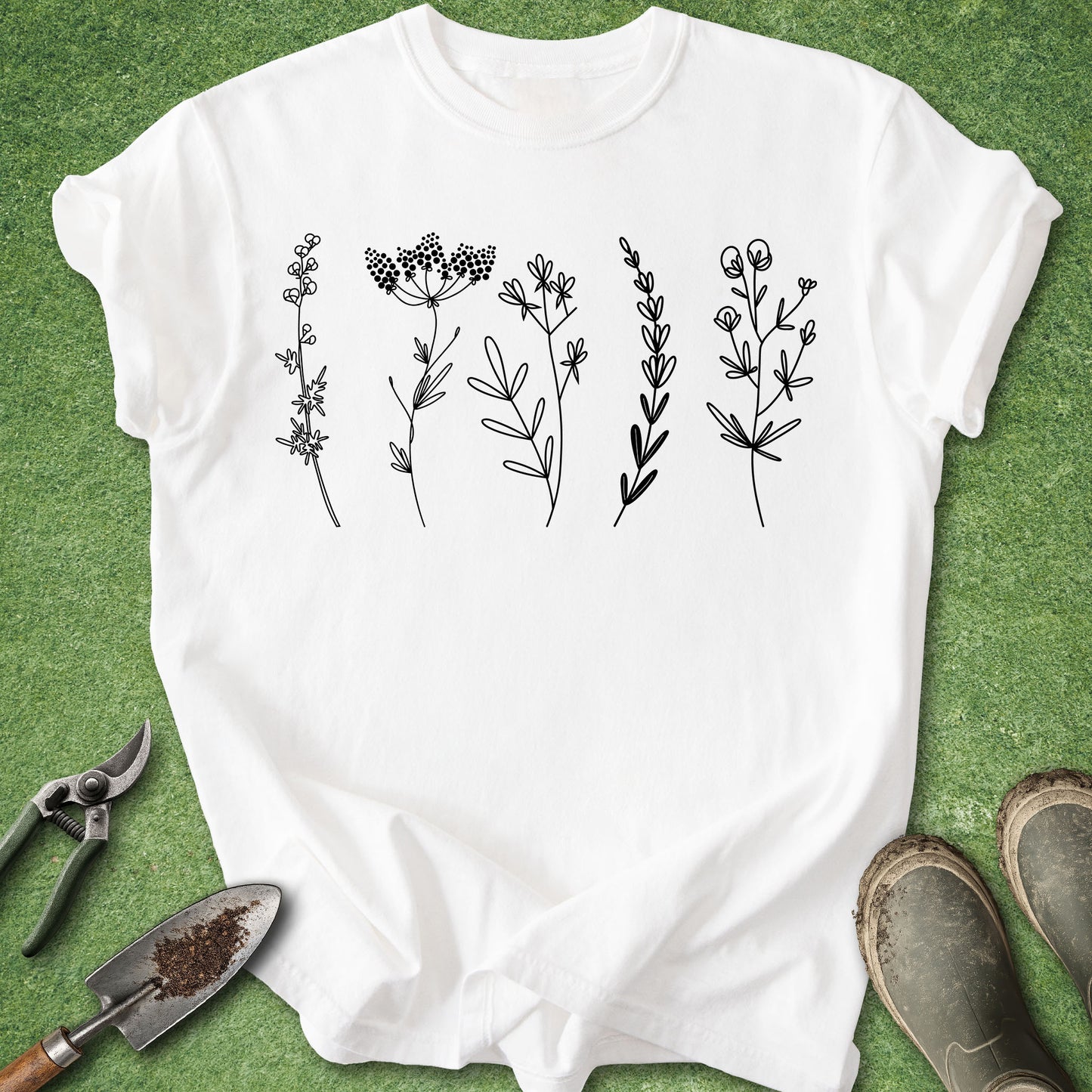 White t-shirt with black floral designs on a green background