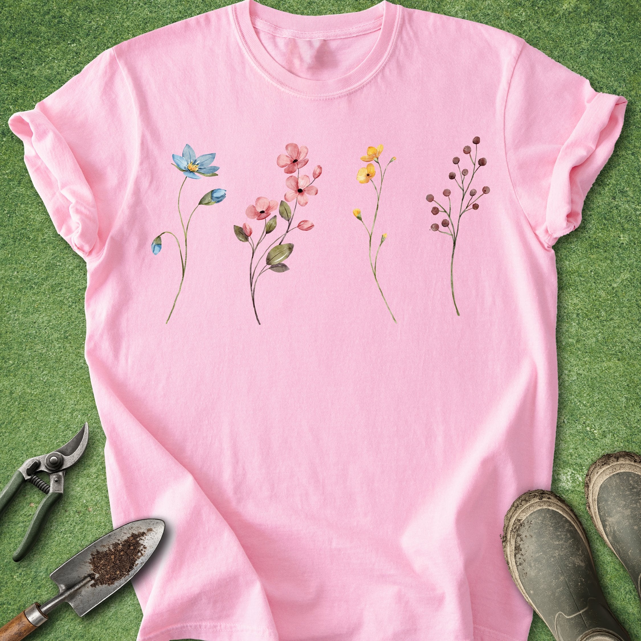 Pink t-shirt with floral designs on a green grass background