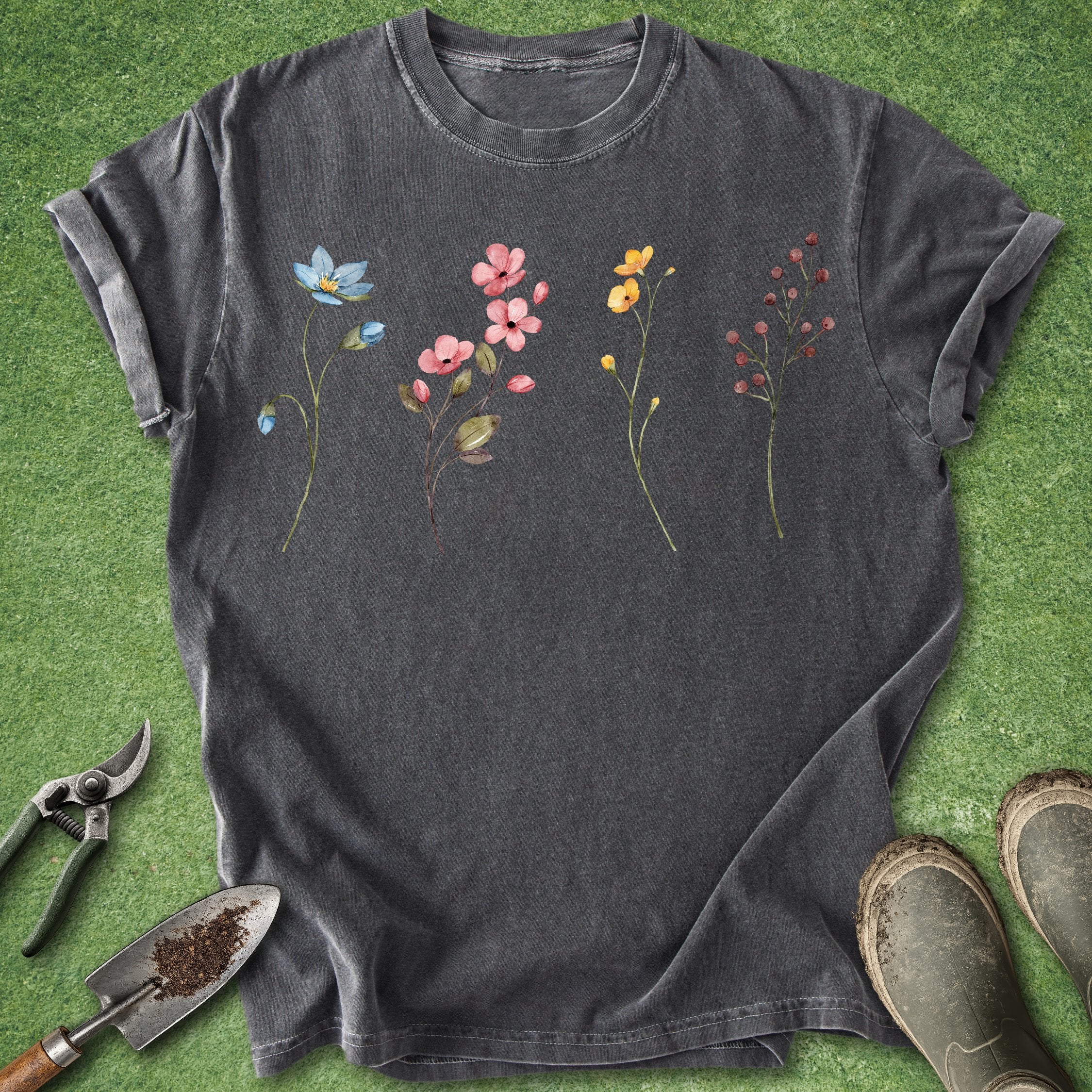 Dark gray t-shirt with floral designs on a green grass background