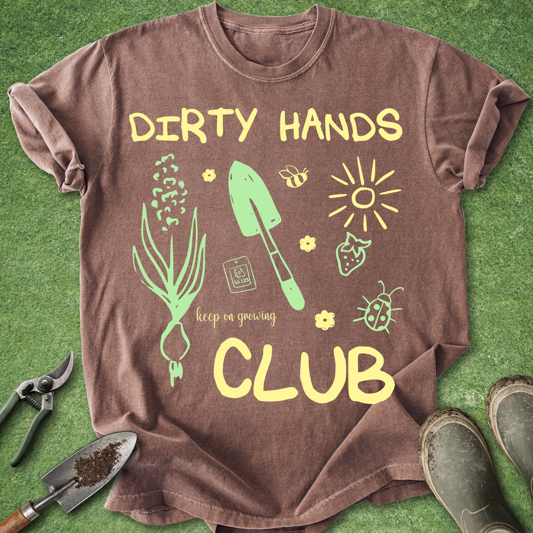 Brown t-shirt with gardening-themed graphics and text on a green background