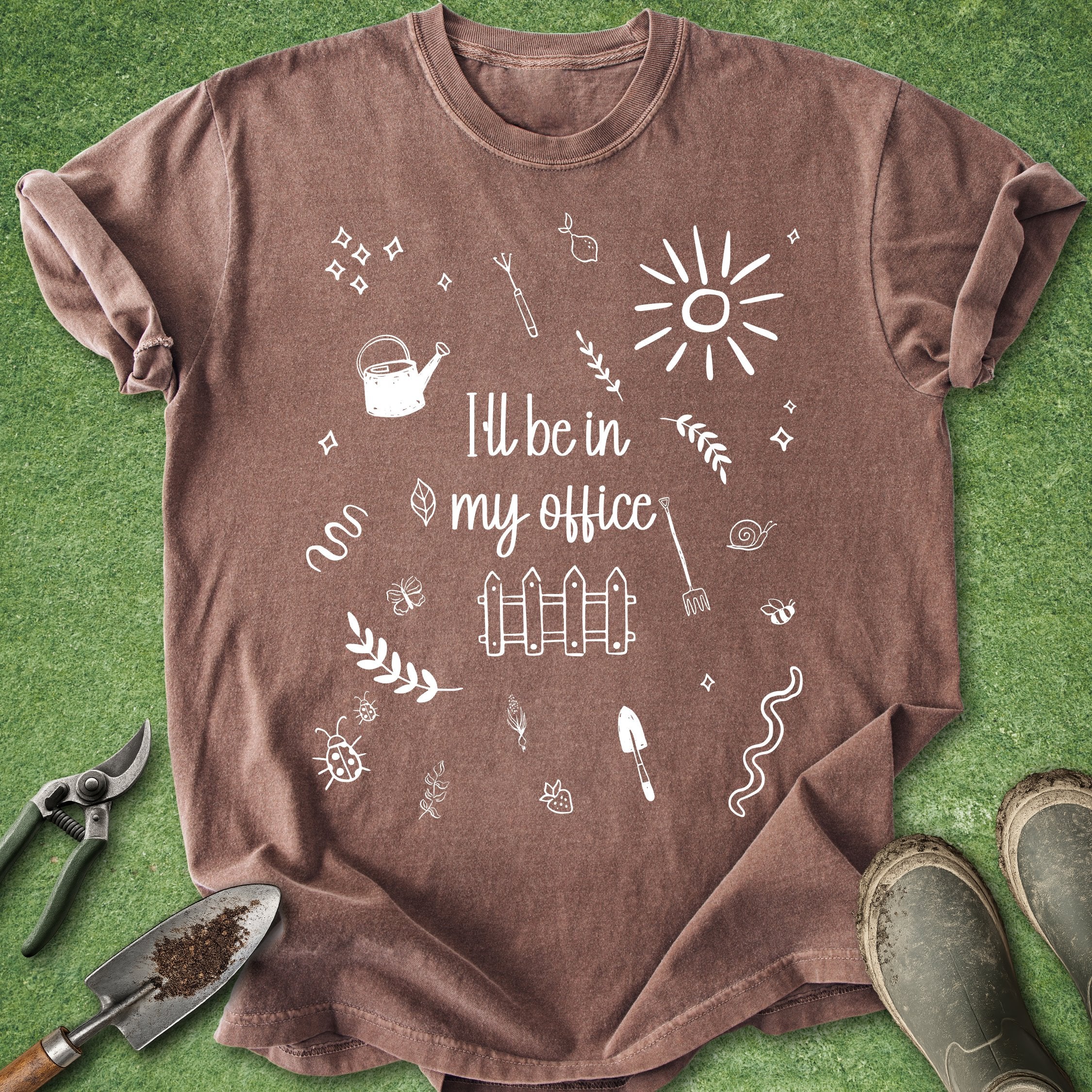 Brown t-shirt with gardening-themed design and text on a green grass background