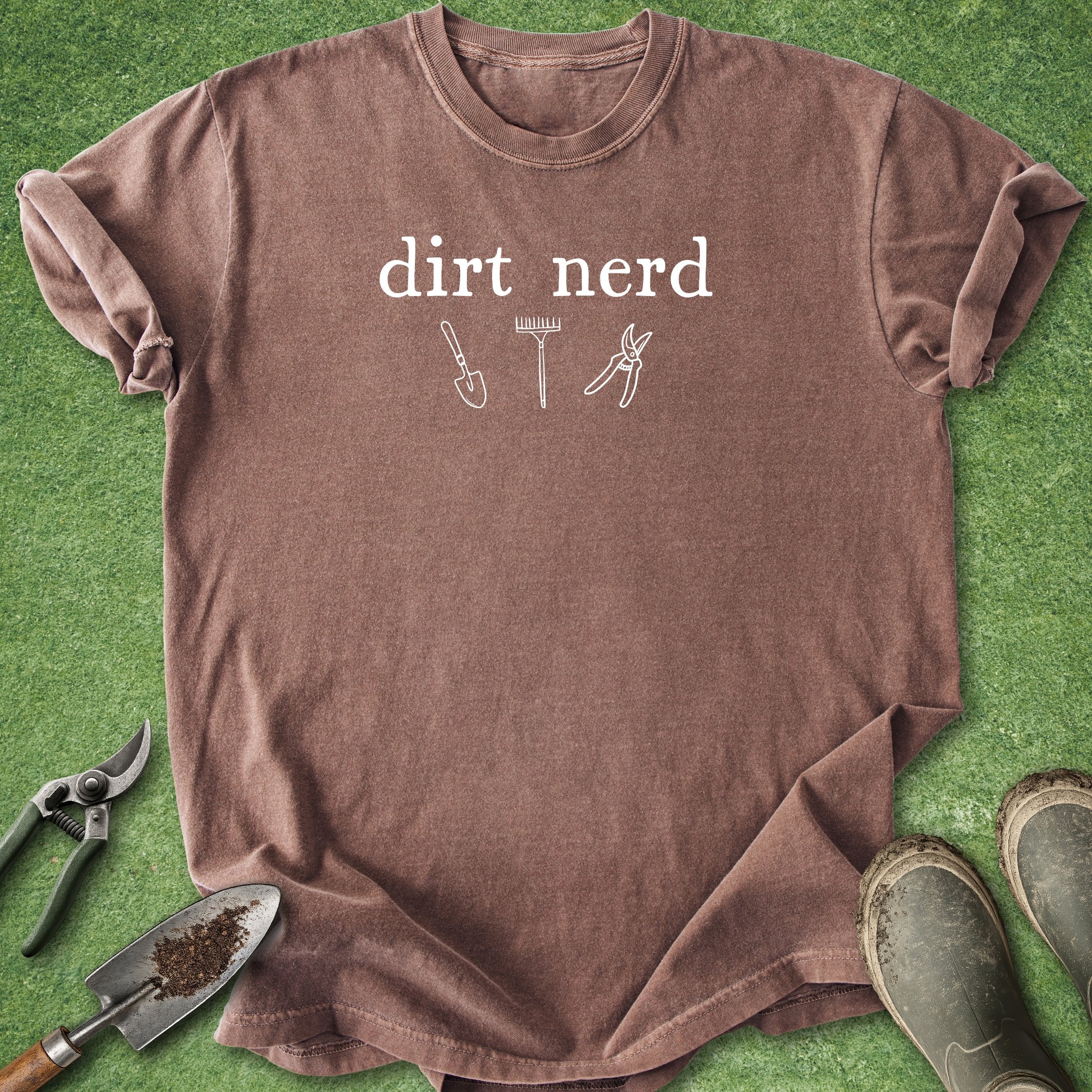 Brown t-shirt with 'Oops, I bought more tools' text and gardening tools on a green background