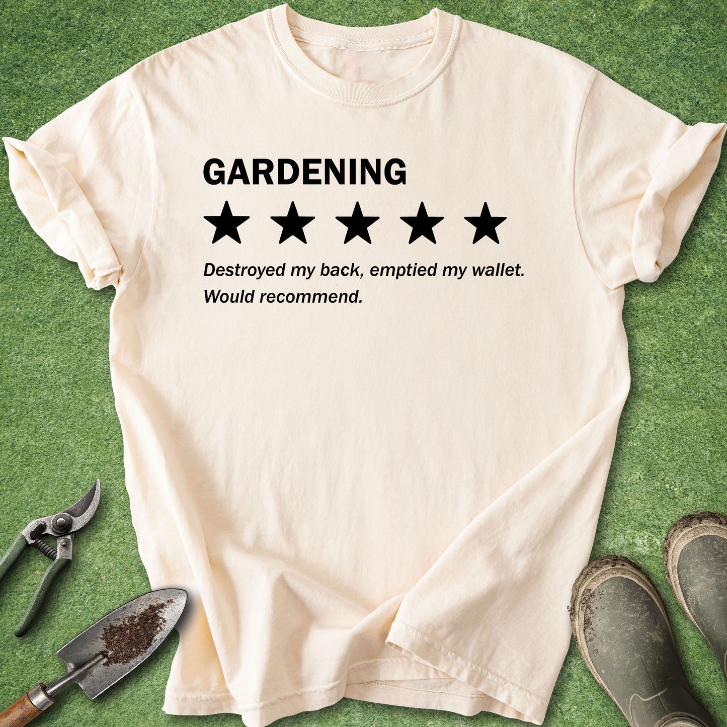 A cream-colored short-sleeve t-shirt with a black graphic print that reads 'GARDENING' above a 1-star rating, with the text 'Destroyed my back, emptied my wallet. Would recommend.