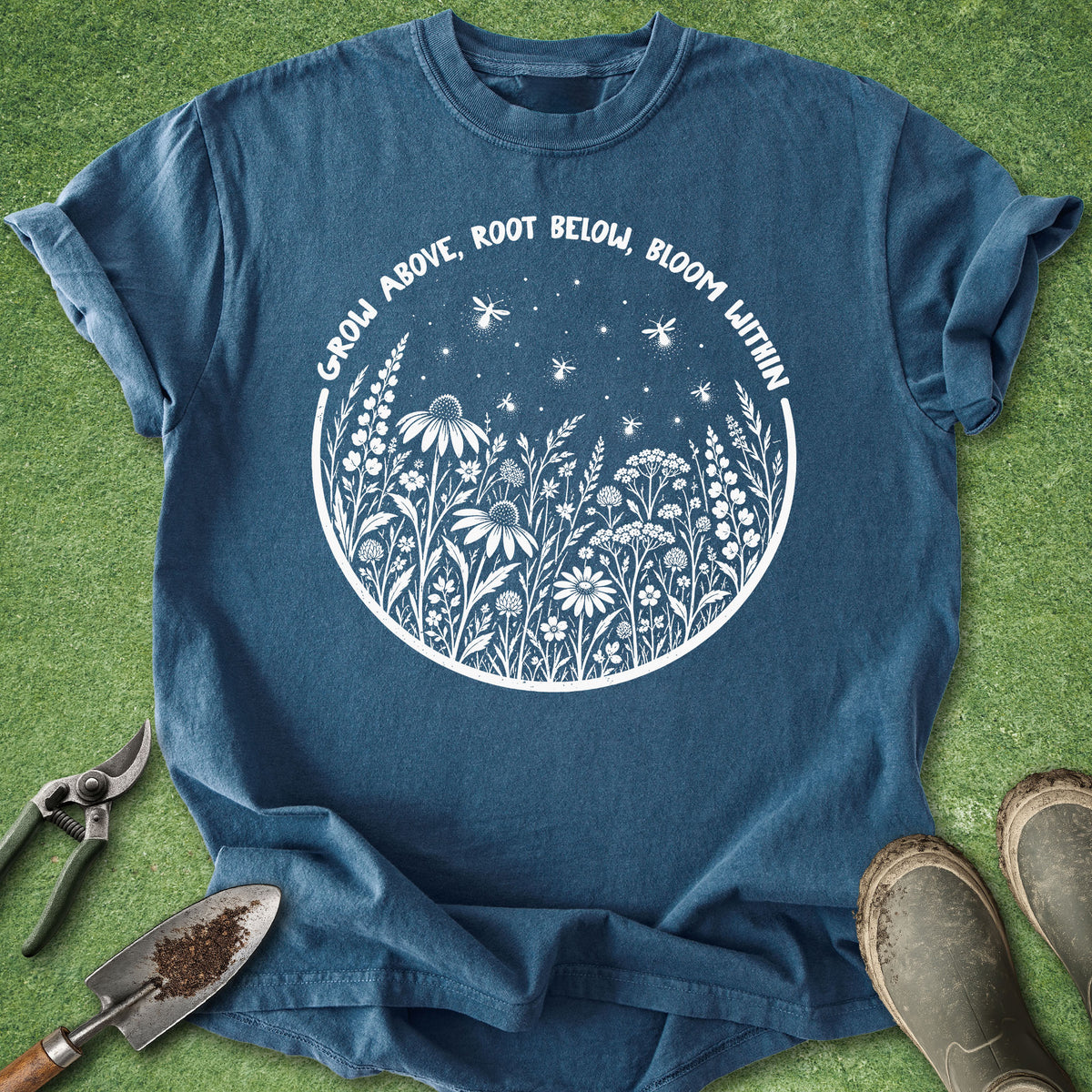 Blue gardening shirt with white wildflowers and fireflies surrounded by the phrase Grow Above, Root Below, Bloom Within.
