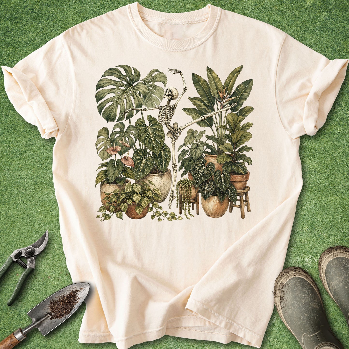 Ivory t-shirt featuring a dancing skeleton surrounded by lush tropical houseplants including Monstera, Philodendron, Pothos and Bird of Paradise.