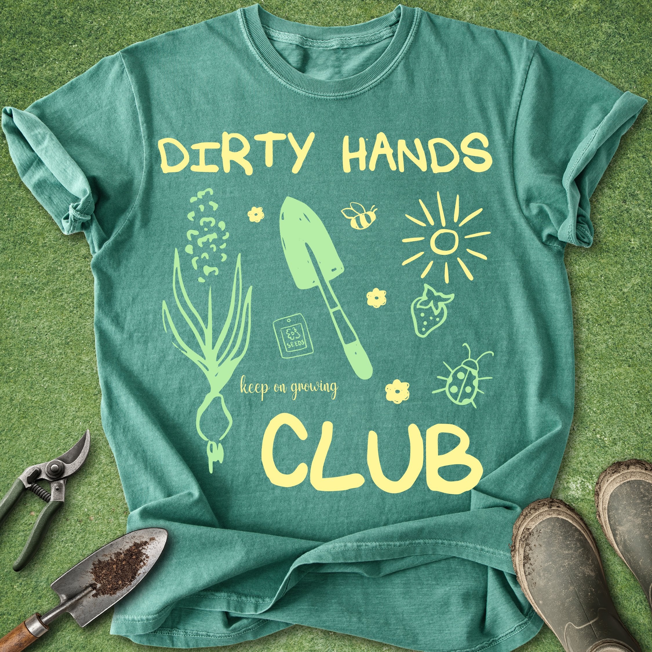 Green t-shirt with gardening-themed design and tools on a green background