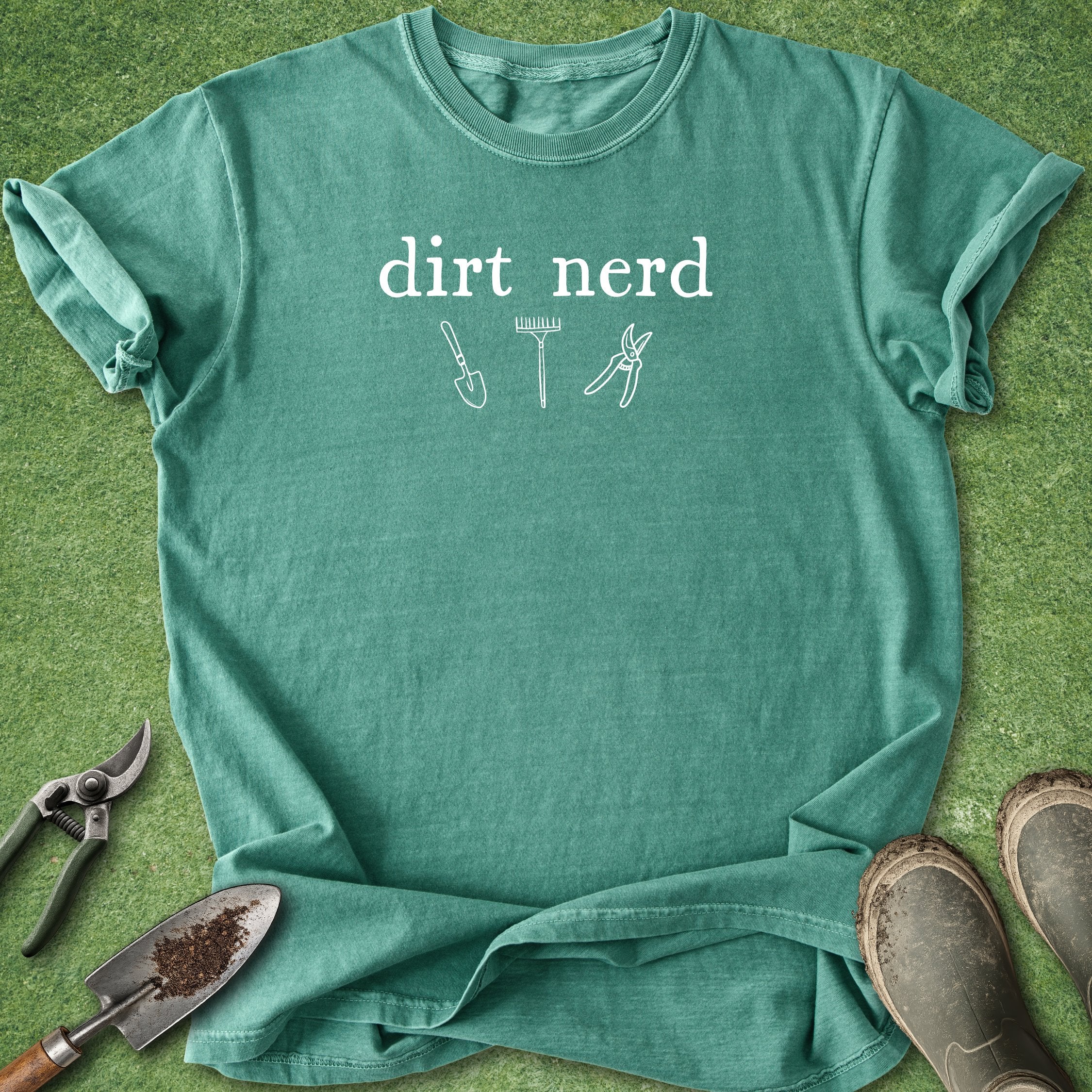 Green t-shirt with 'dirt nerd' text and gardening tools on a grass background