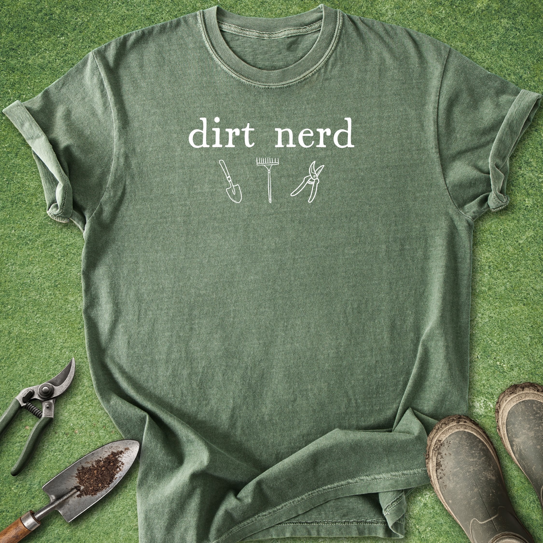 Green t-shirt with text and tool graphics on a grass background