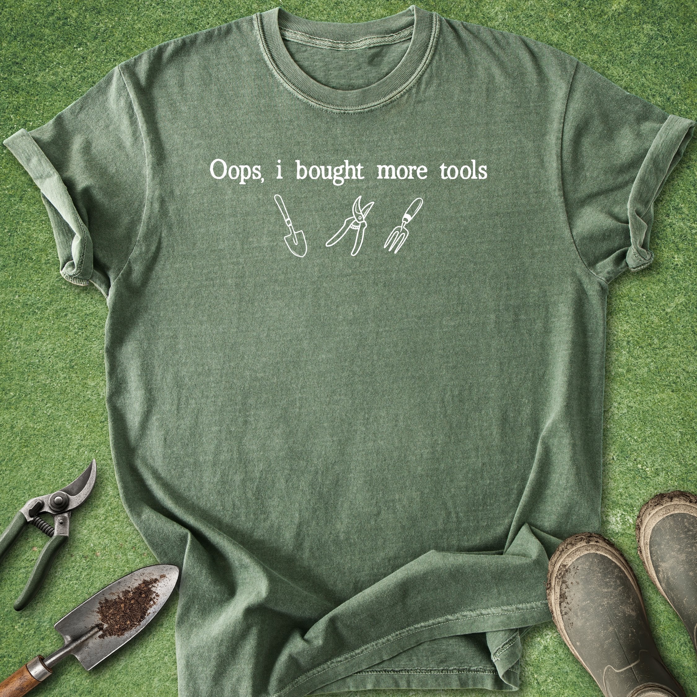 Green t-shirt with text and tool graphics on a grass background