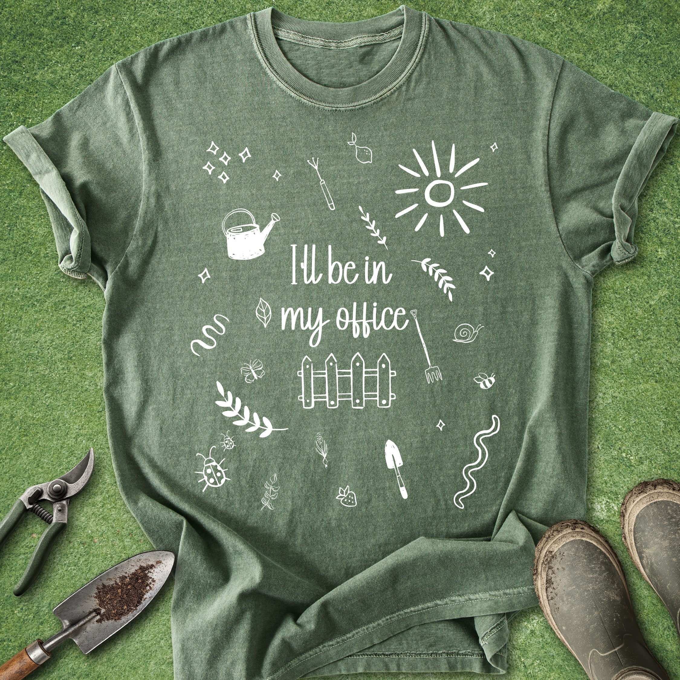 Green t-shirt with gardening-themed design and text on a grass background