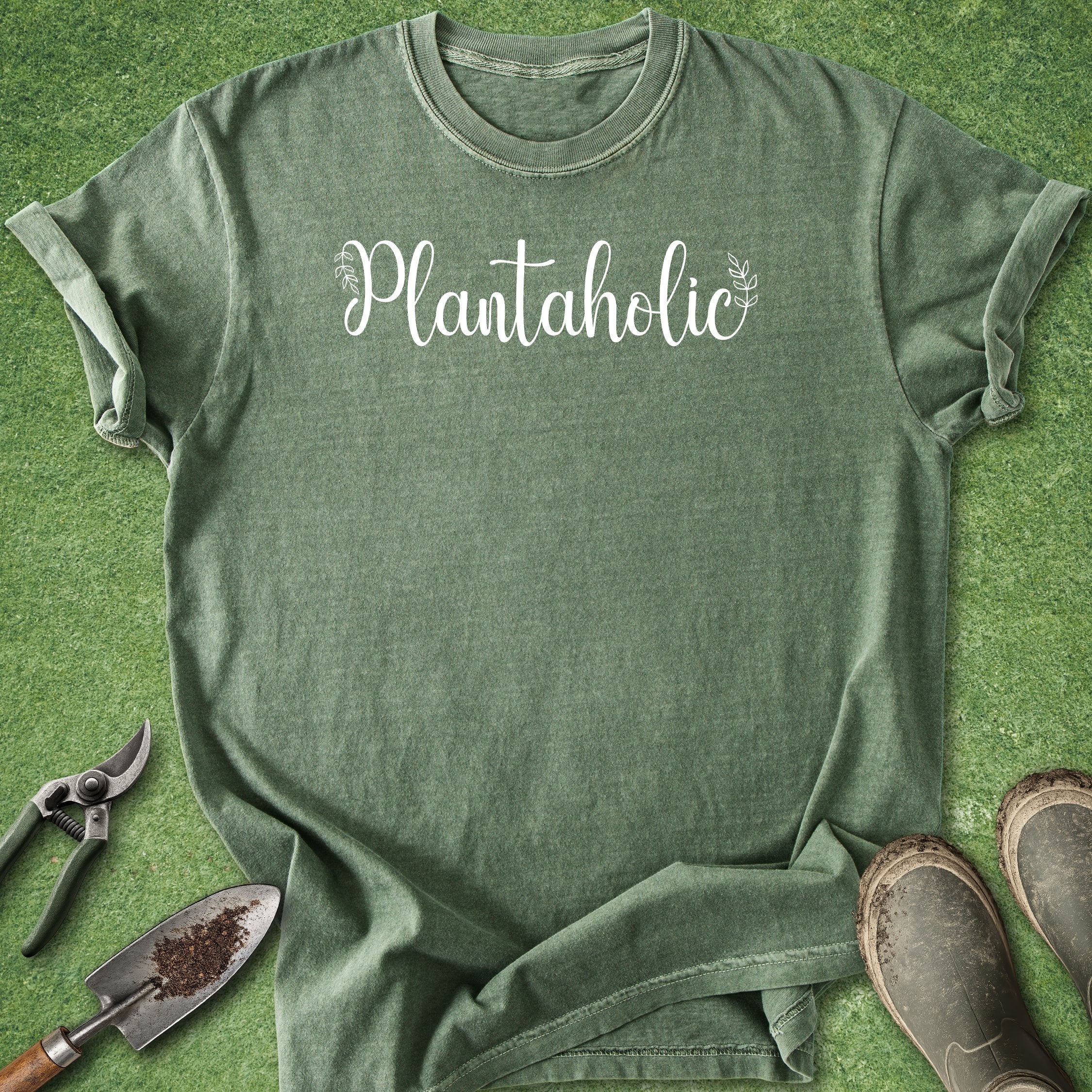 Green t-shirt with 'Plantaholic' text on a grass background