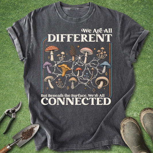 Dark gray t-shirt featuring colorful mushrooms connected by a white mycelium network with the quote We Are All Different But Beneath the Surface We’re All Connected.
