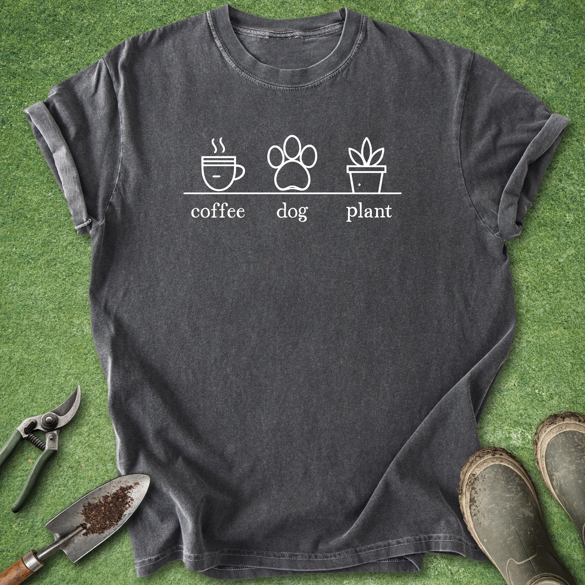 Black t-shirt with 'coffee', 'dog', and 'plant' graphic on a grass background